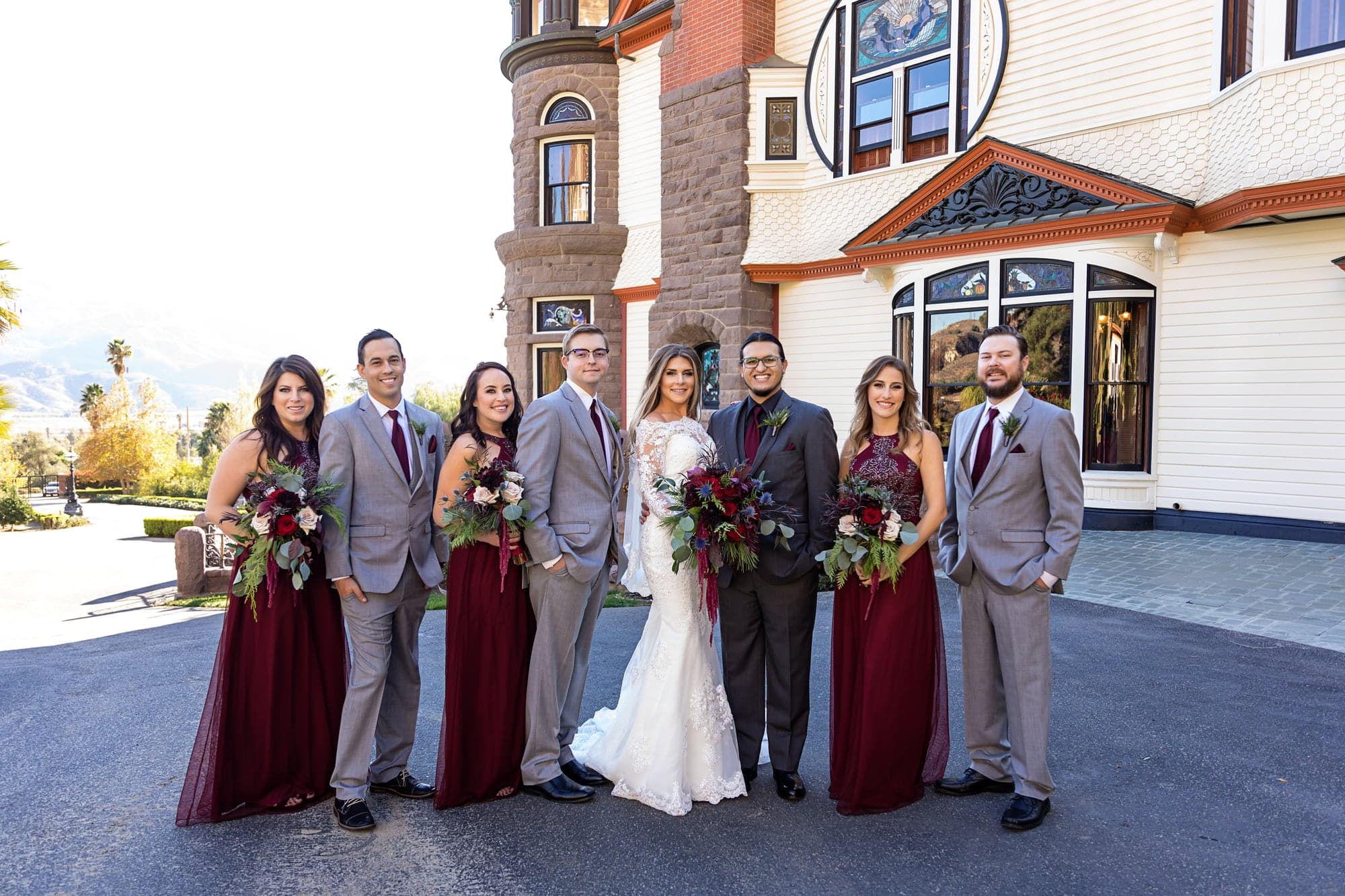 Courtney and John with their wedding party outside the mansion