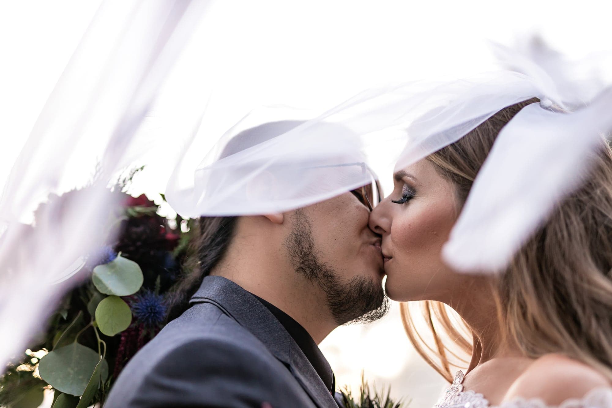 Courtney and John beneath a flowing veil