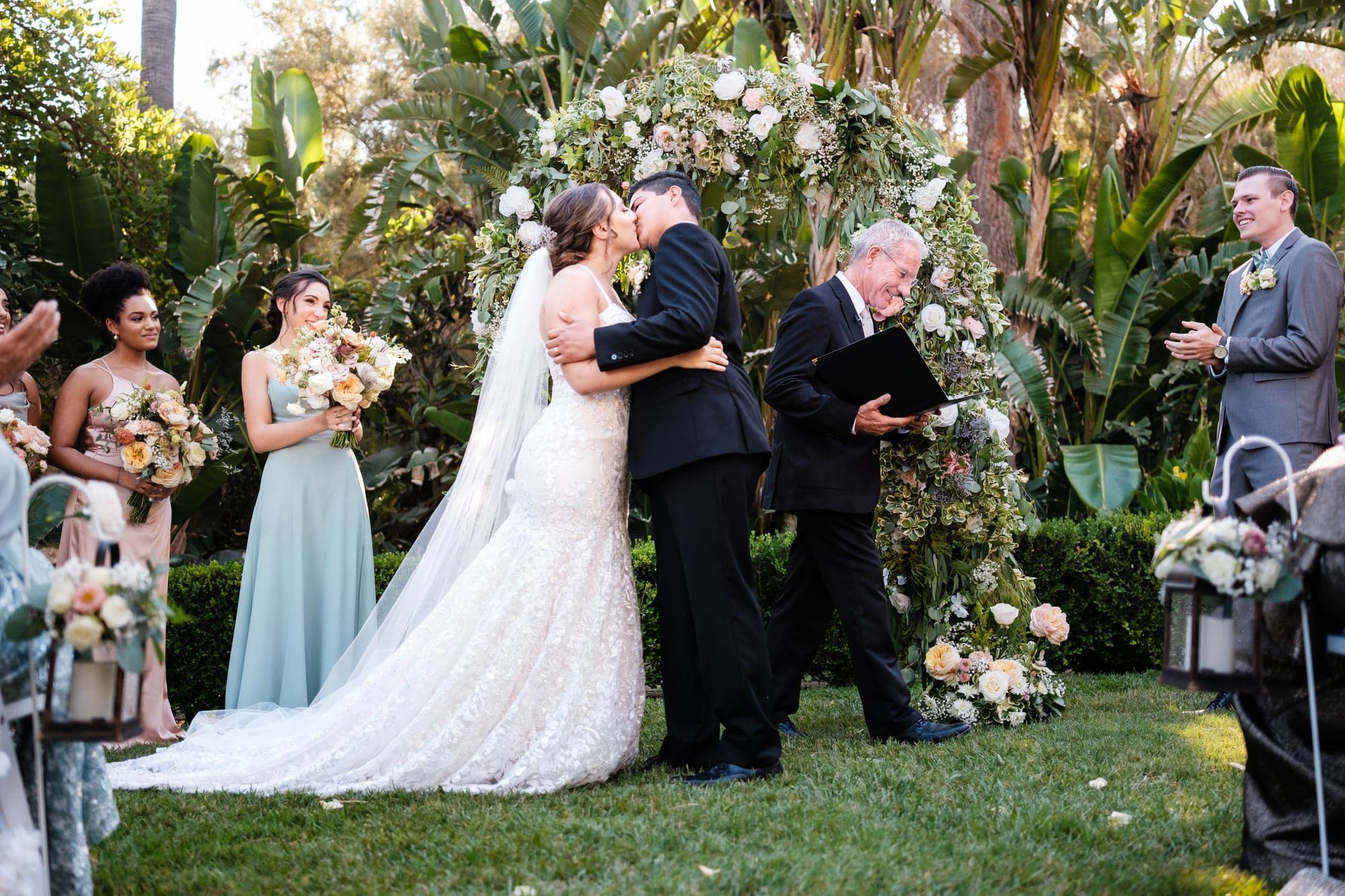 Haley and Clayton exchanging vows beneath a floral garden arch