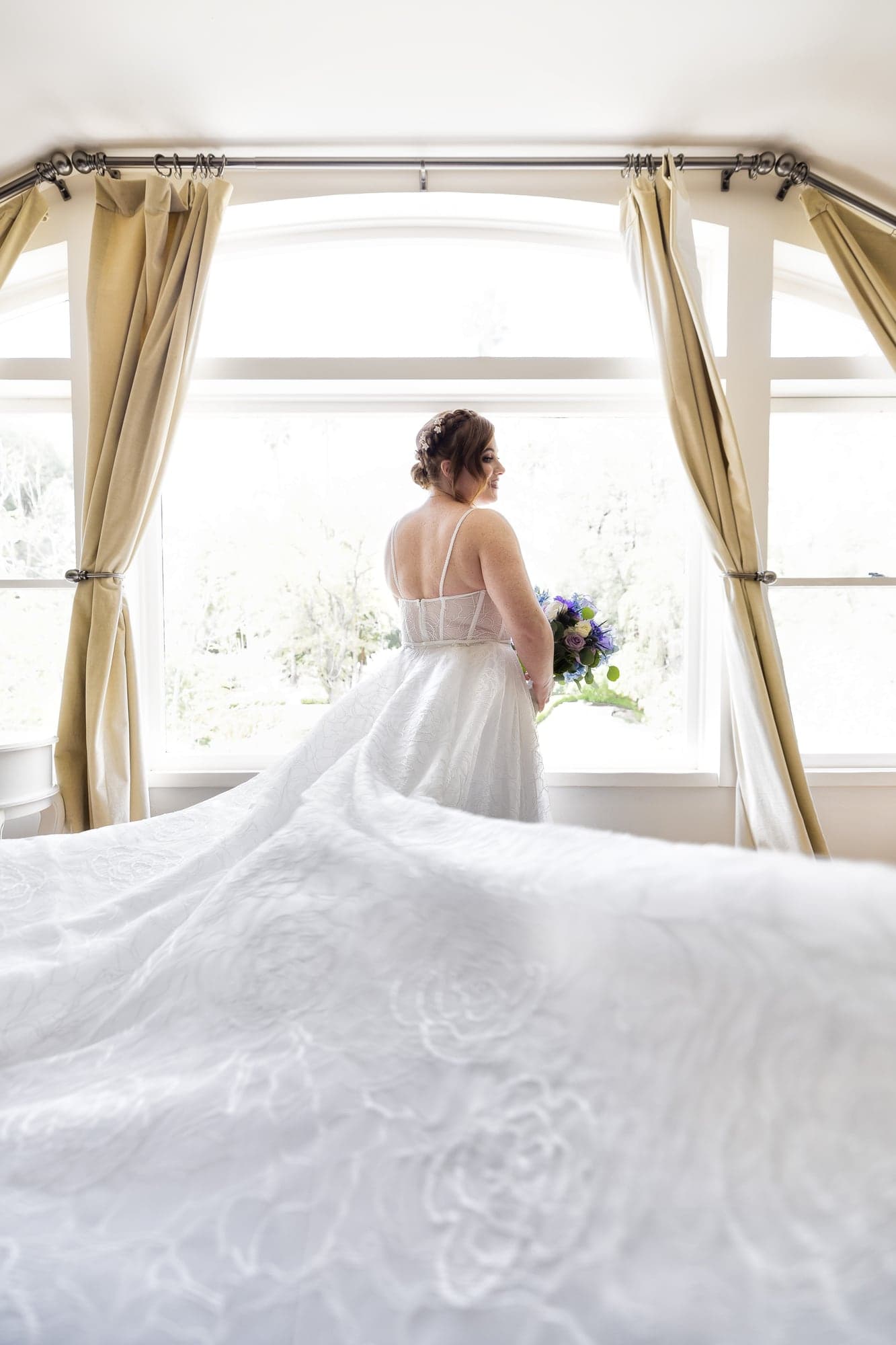 Rachel framed in a narrow shaft of light beneath her wedding veil