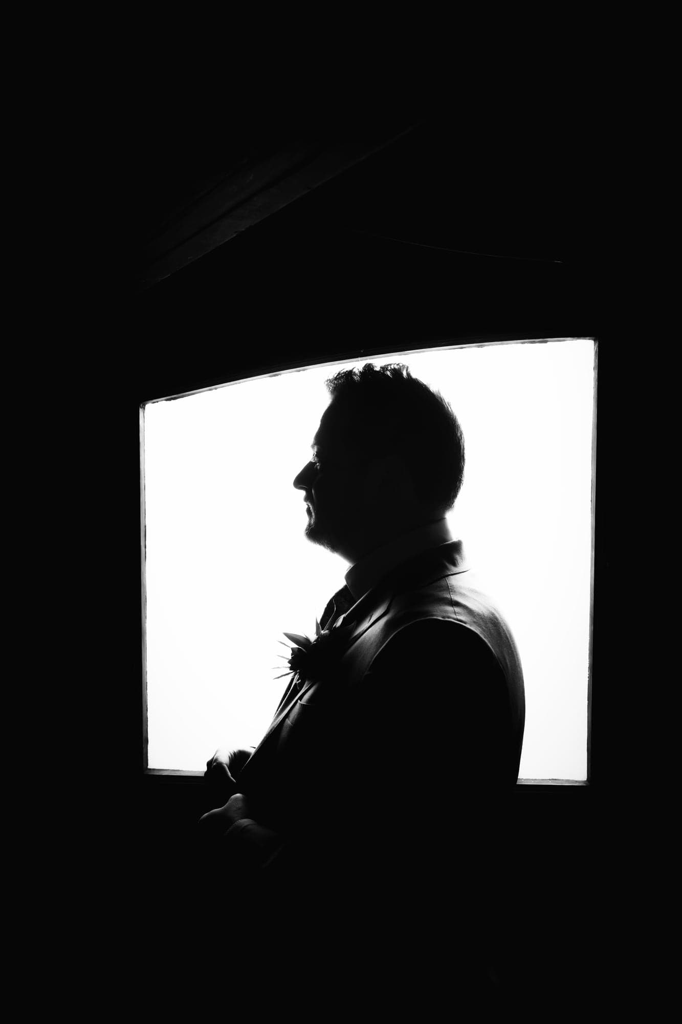 Travis silhouetted in profile inside a dark room at Newhall Mansion
