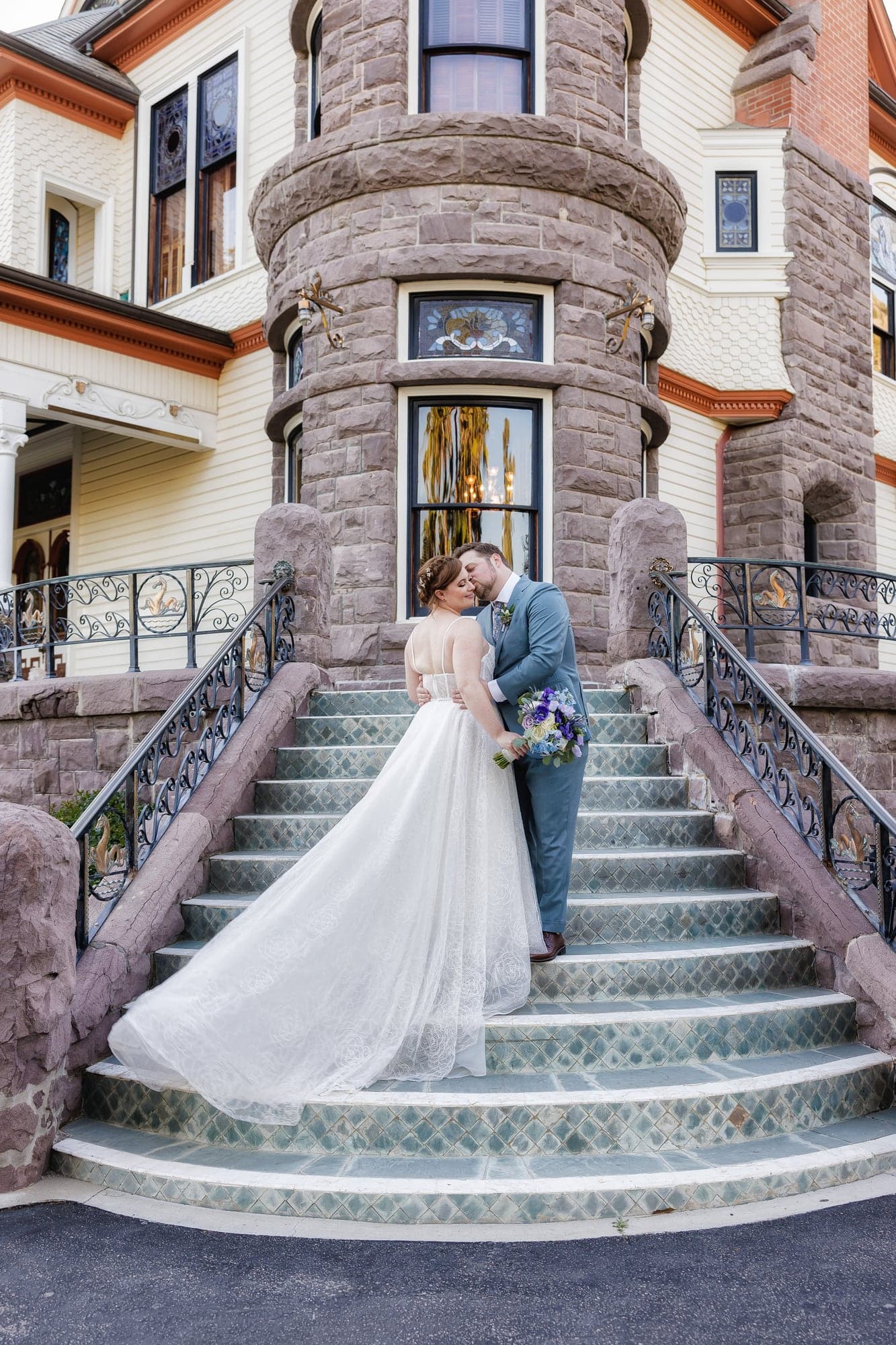 Rachel and Travis standing together on the stone turret staircase at Newhall Mansion
