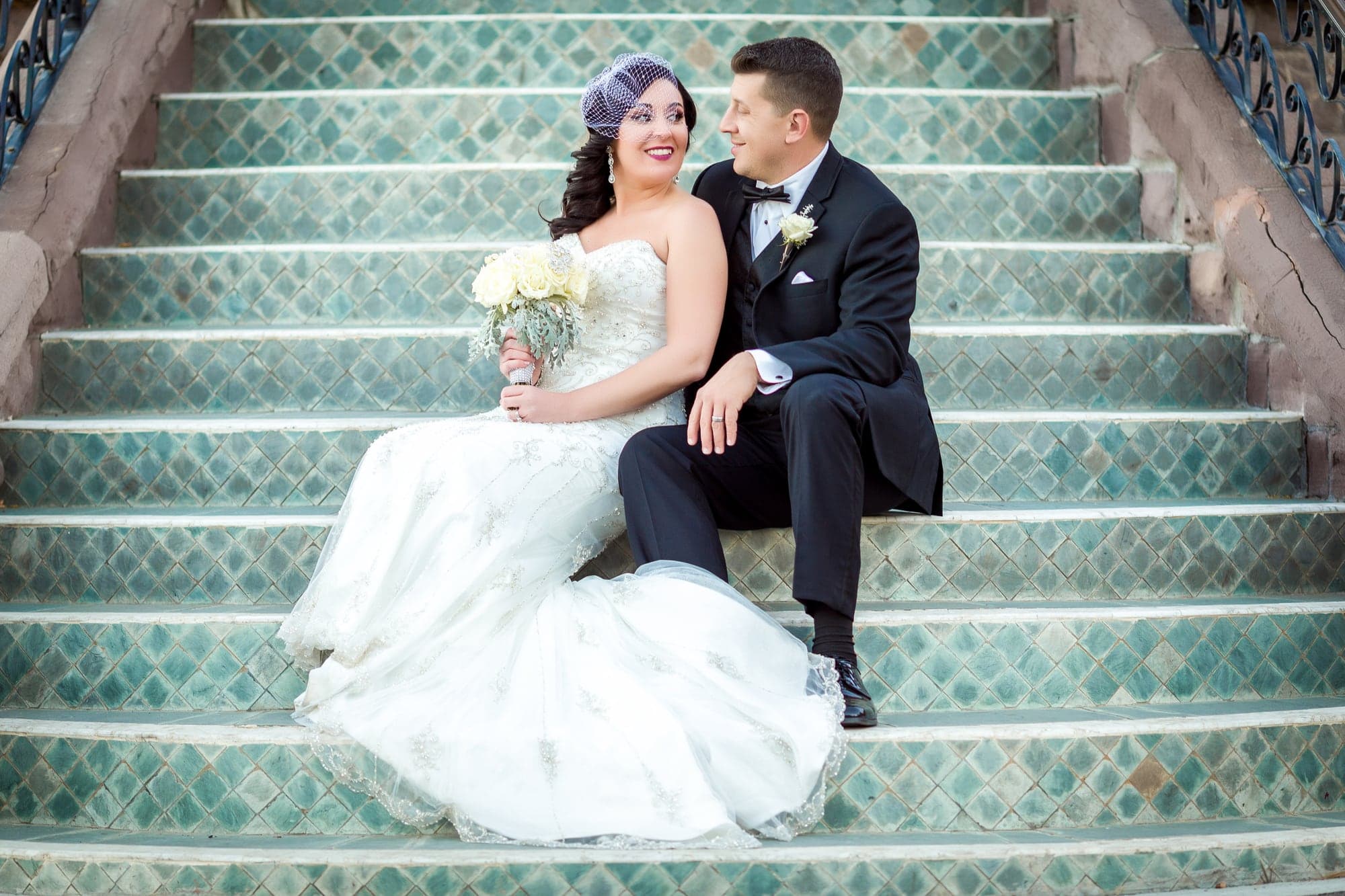 Tiffany and Josh seated on the mansion steps