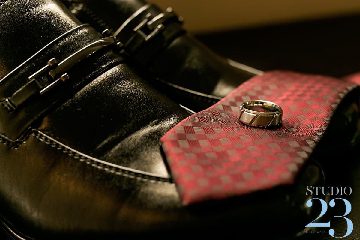 Joshua's wedding ring and black shoes