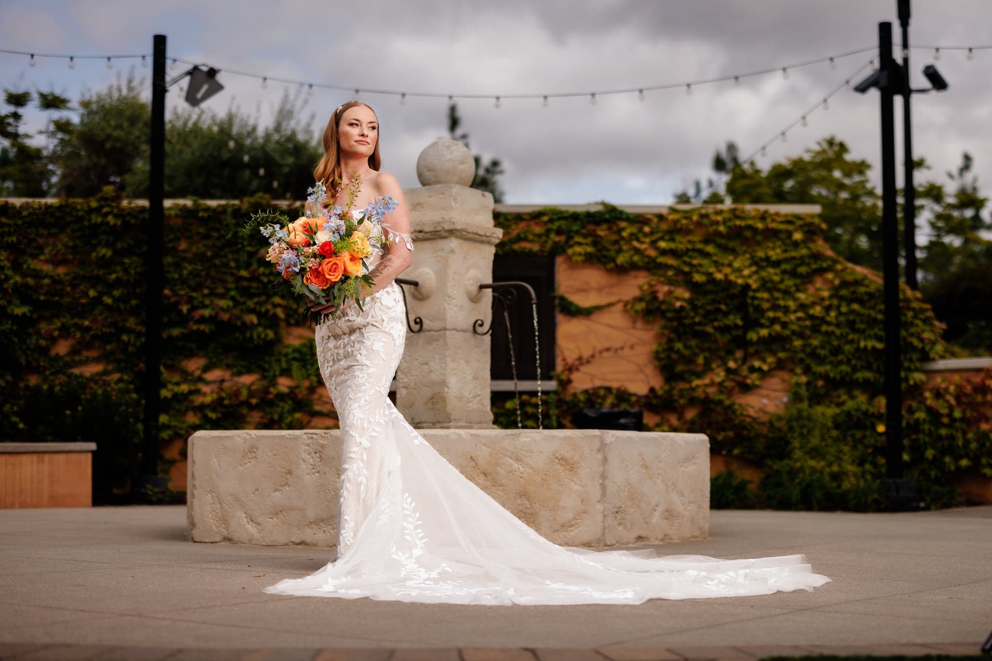 Katie posing outdoors with her colorful wedding bouquet