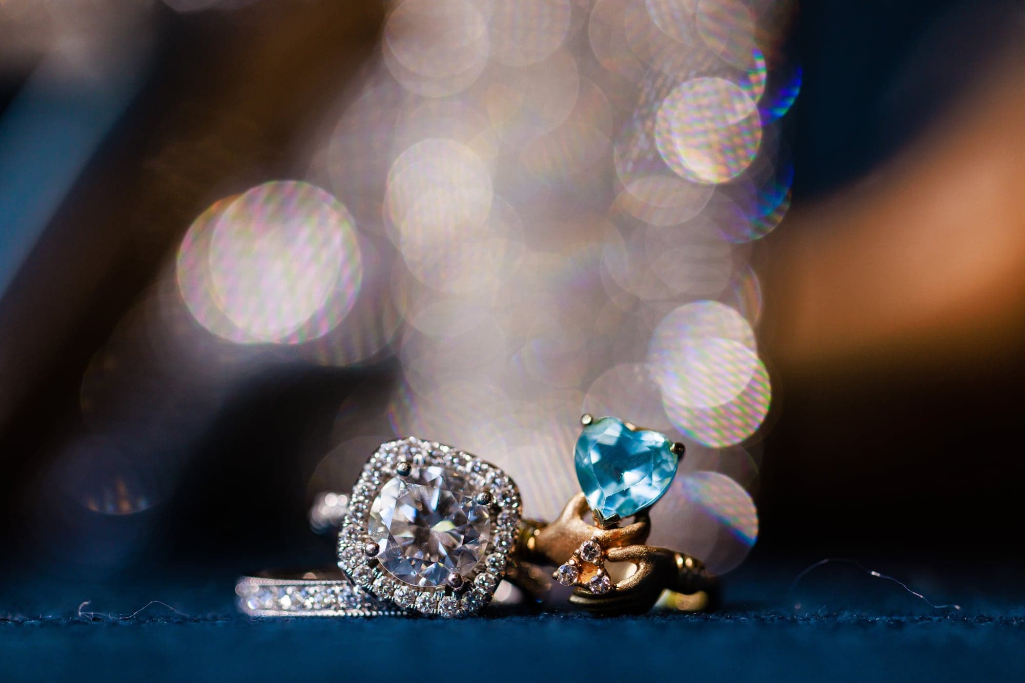 Mary and Tyler's wedding rings photographed against a deep blue surface at Padua Hills Theatre