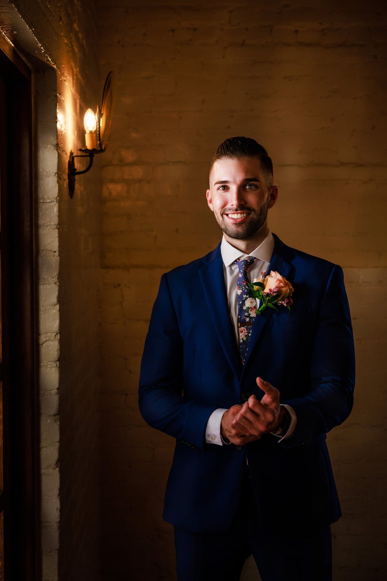 Tyler standing in a blue suit before the oak-shaded ceremony at Padua Hills Theatre