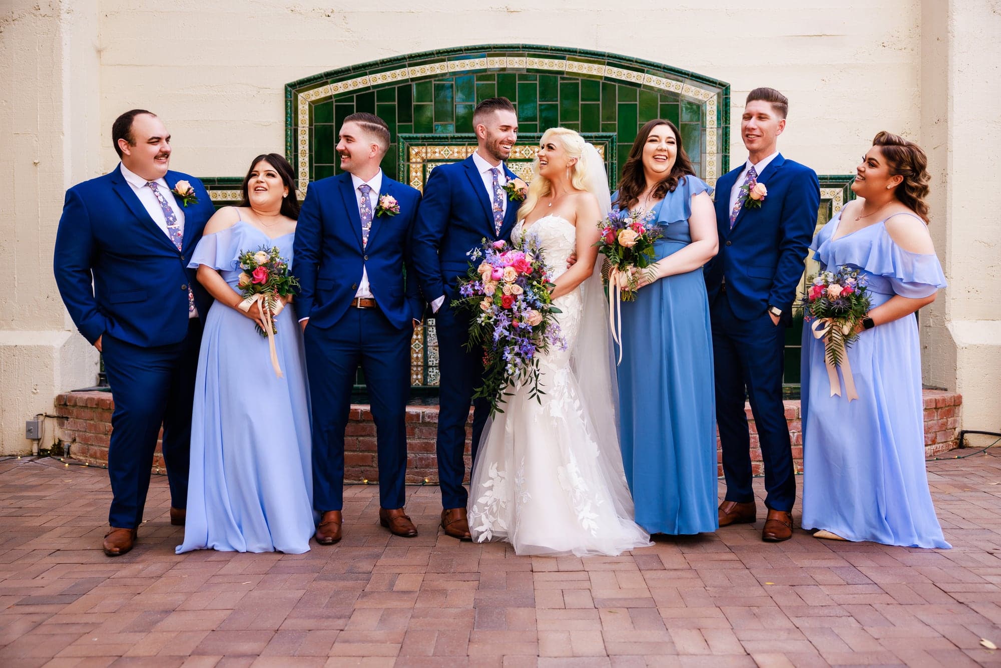 Mary and Tyler with their family and wedding party in the Padua Hills Theatre courtyard