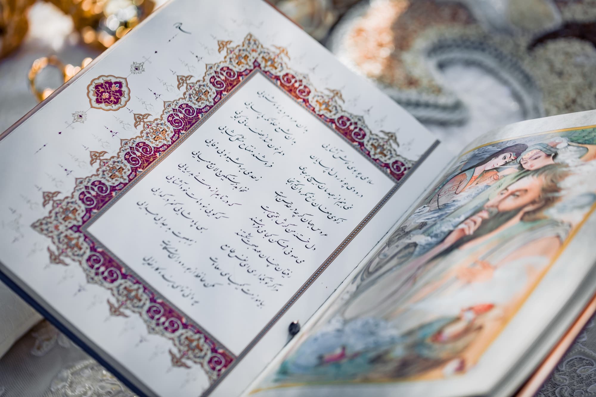 Illuminated marriage book open to hand-painted pages on the sofreh aghd at a Persian wedding