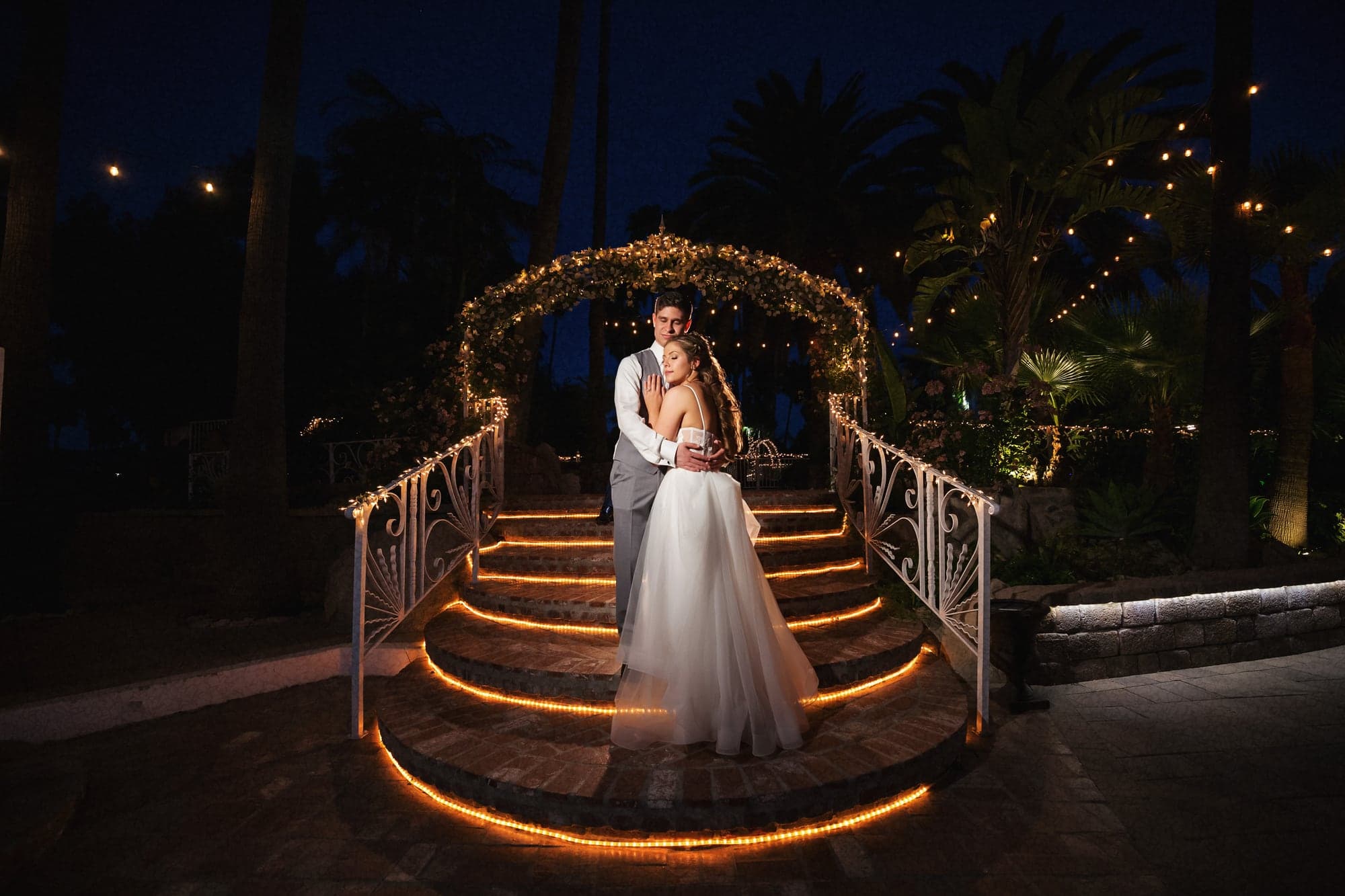 Mary and Cole on an illuminated bridge after sunset