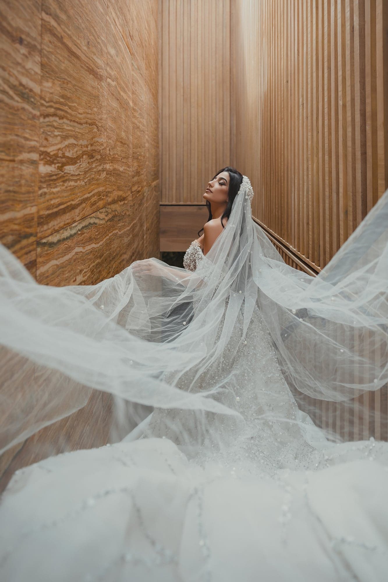 Julian posing on a staircase as her long veil spreads behind her