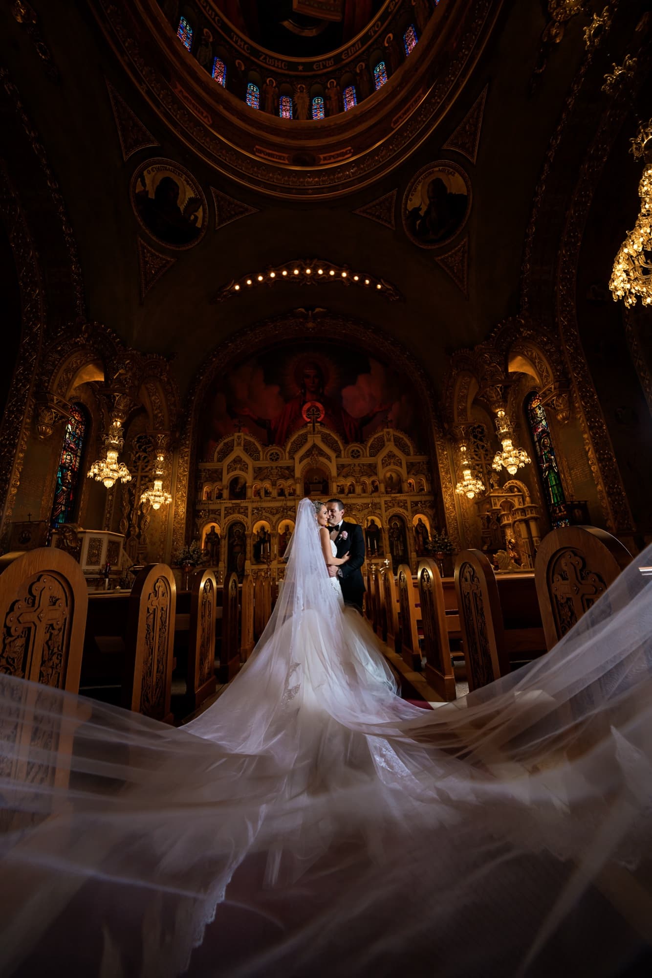 Laura's cathedral veil fanned across the aisle beneath the gilded altar and chandeliers of Saint Sophia Cathedral