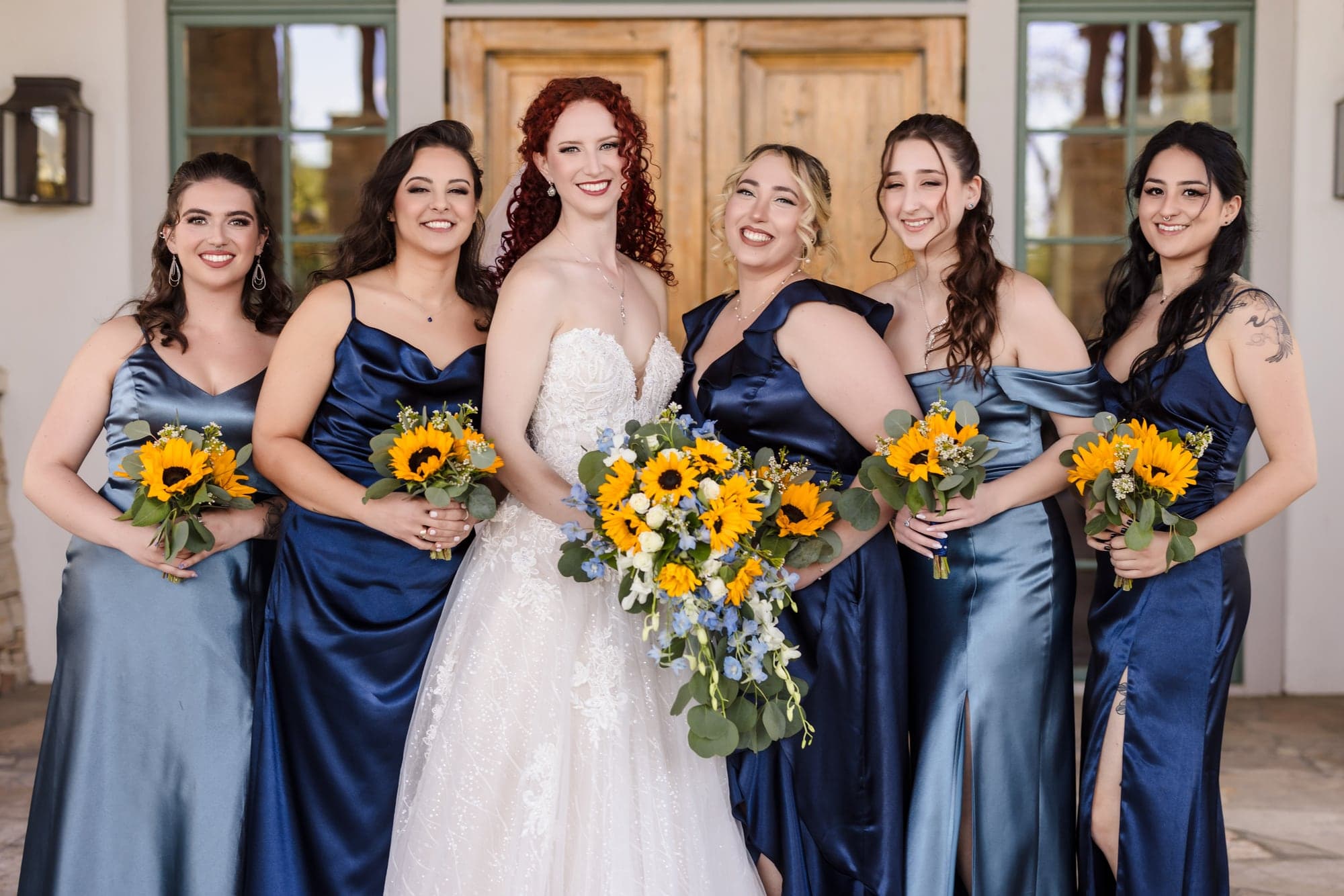 Maria with her bridesmaids carrying sunflower bouquets