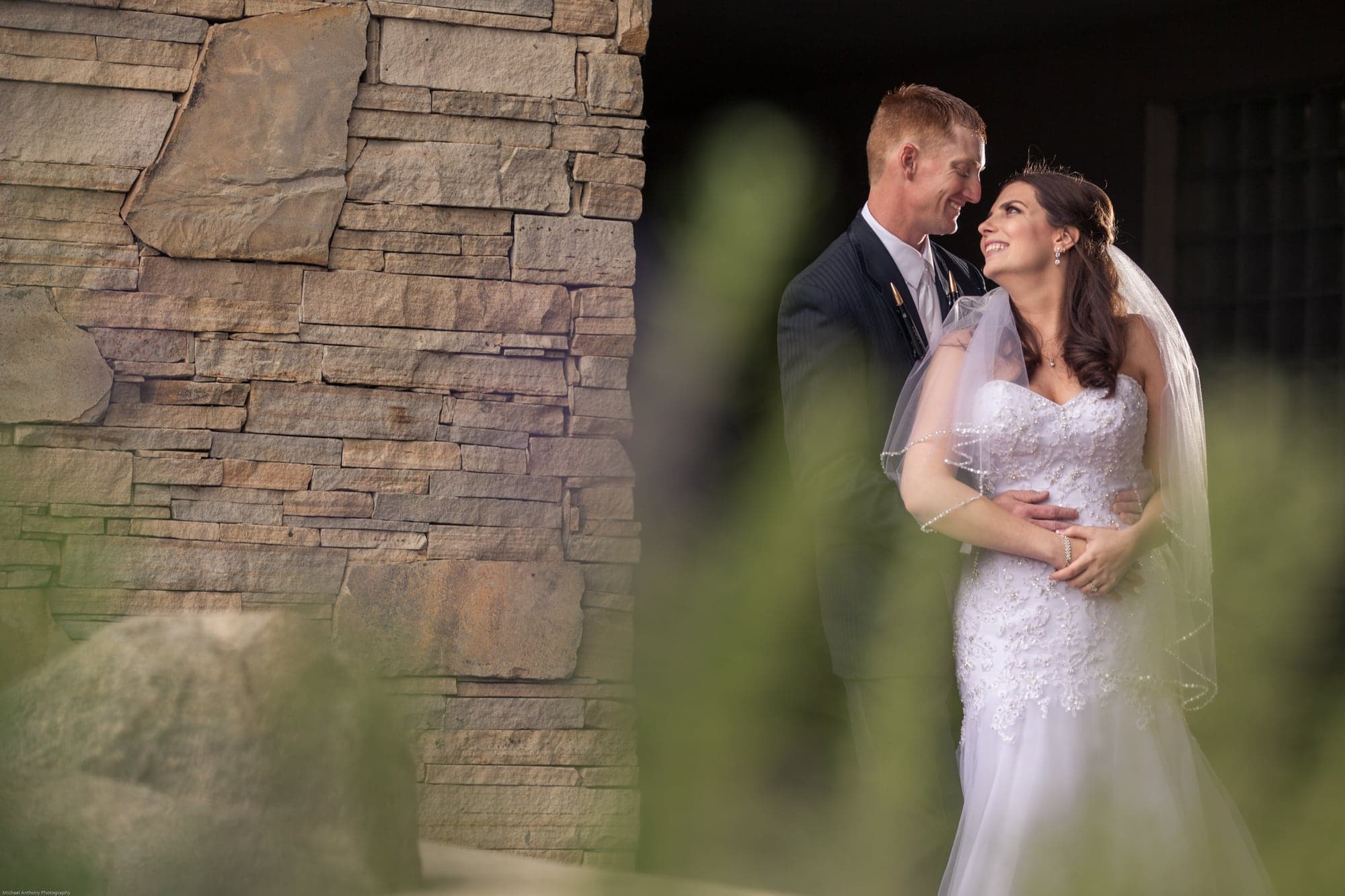 Newlyweds photographed beside the ranch stonework