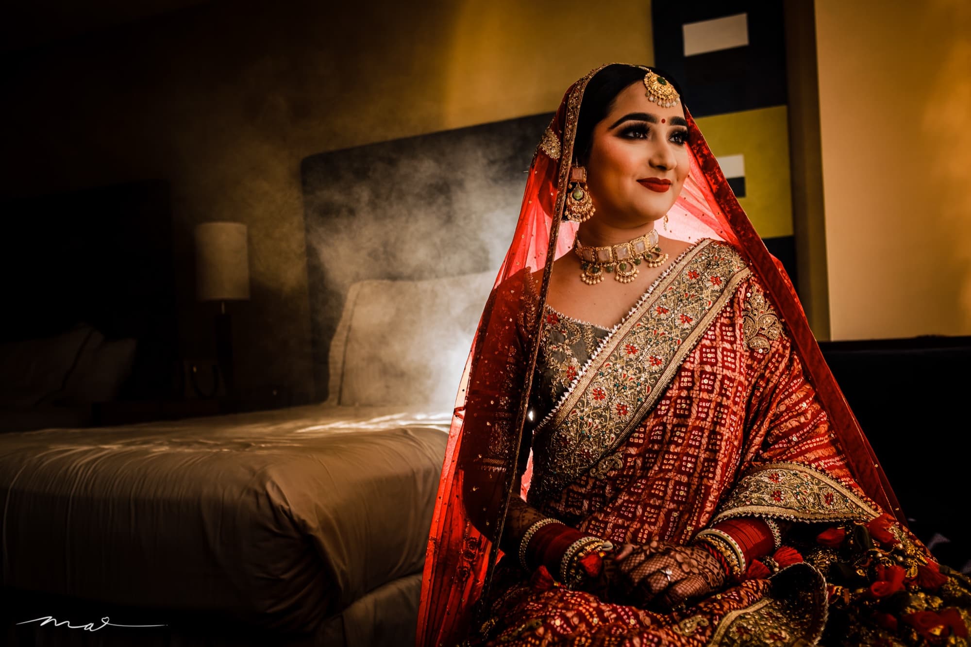 Harmen's red dupatta cascading down the staircase beneath a golden arch