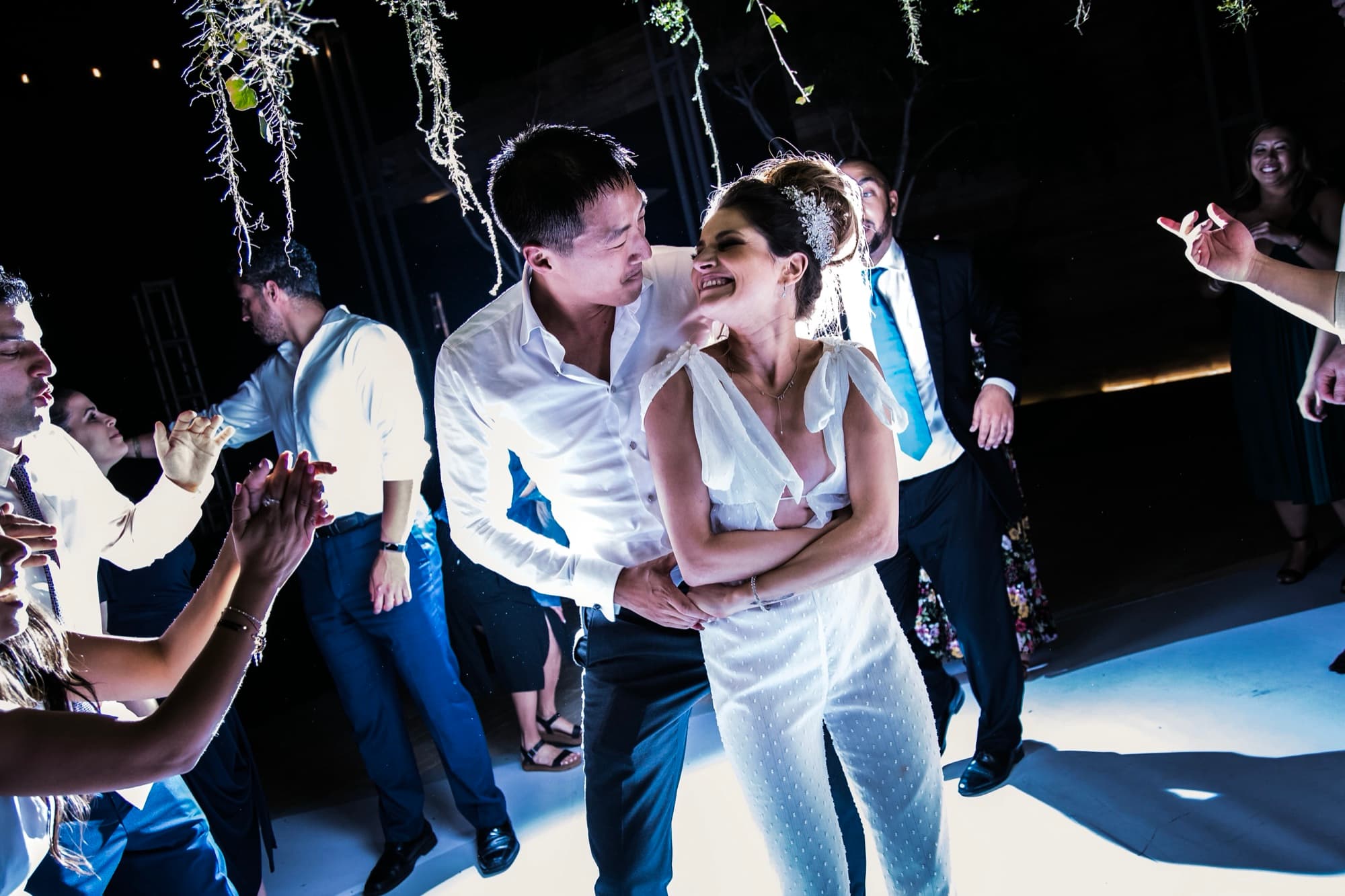 Yana and Jonathan exchanging vows beneath the pampas and coral ginger arch on the beach deck at Solaz