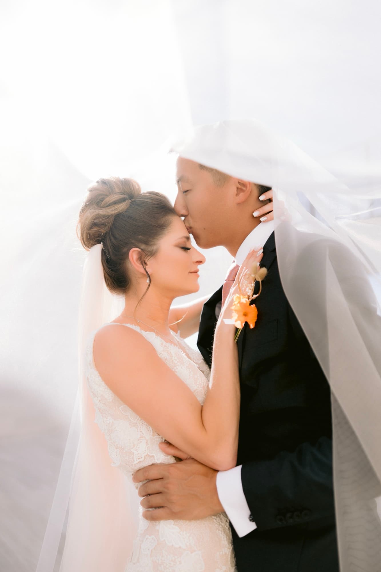 Jonathan kissing Yana's forehead beneath her veil after the ceremony