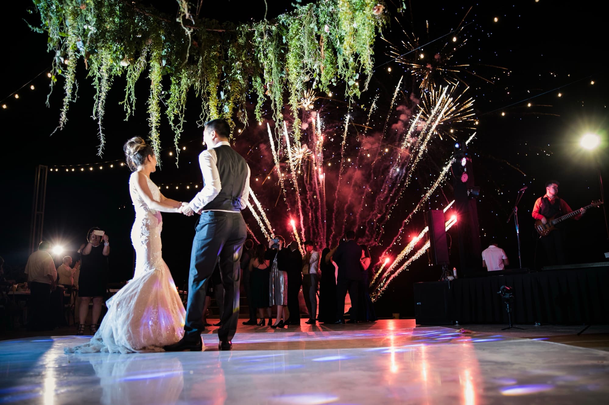 Yana and Jonathan's first dance as fireworks erupt behind the dance floor at Solaz Los Cabos