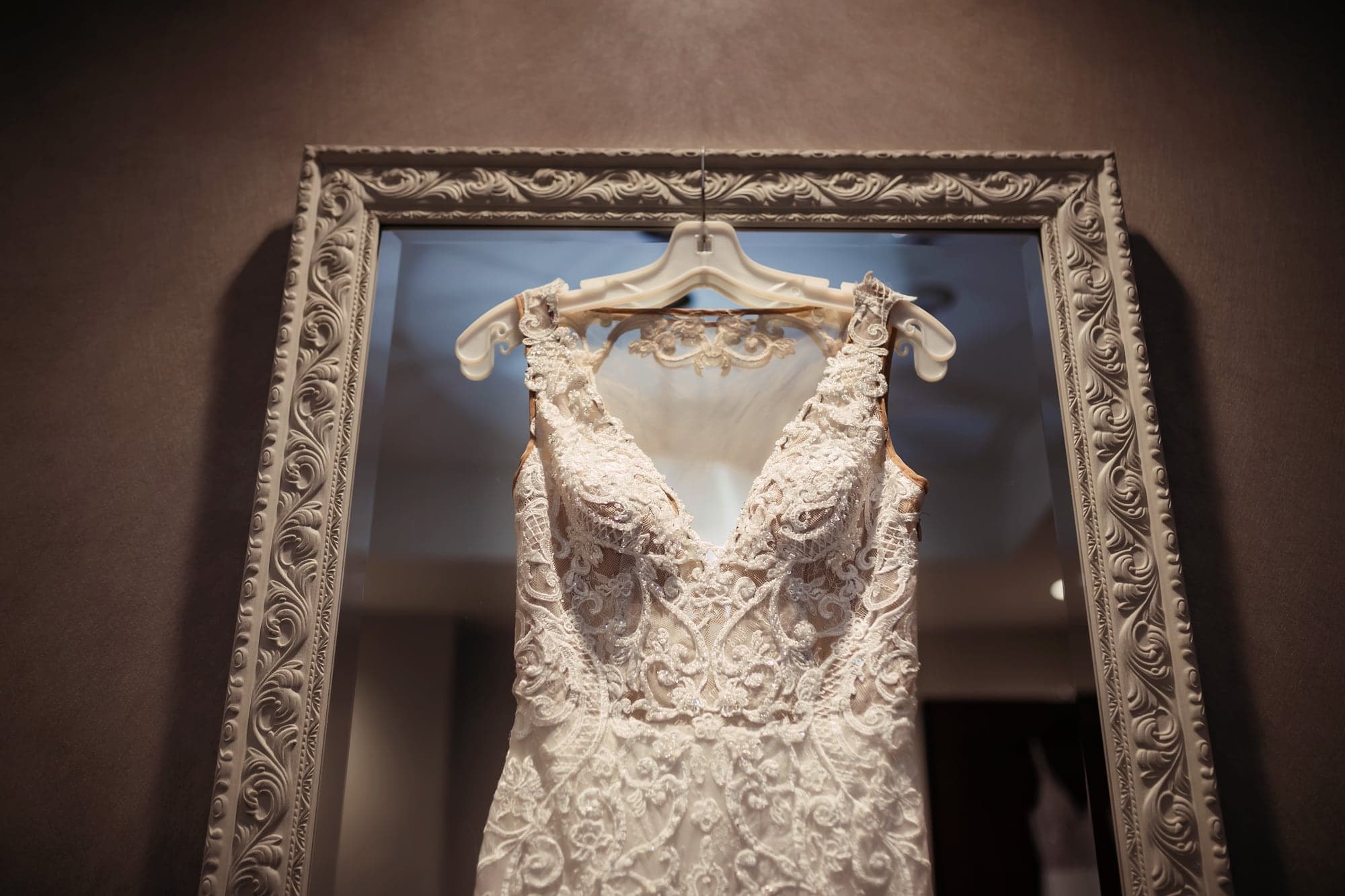 Lace wedding dress displayed in an ornate frame