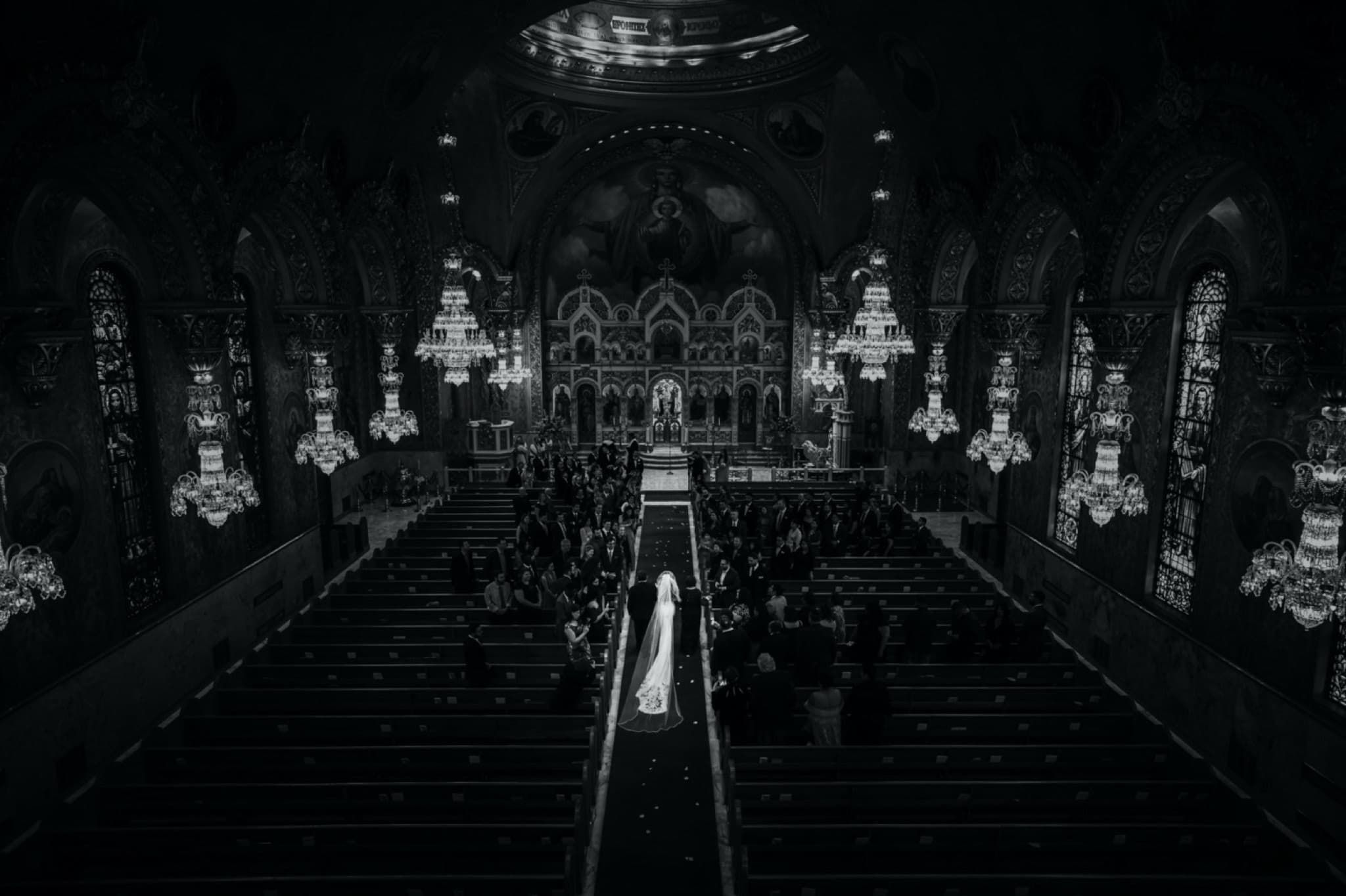 Black and white view from the balcony of St. Sophia Cathedral, Christina's train pouring down the aisle beneath the chandeliers