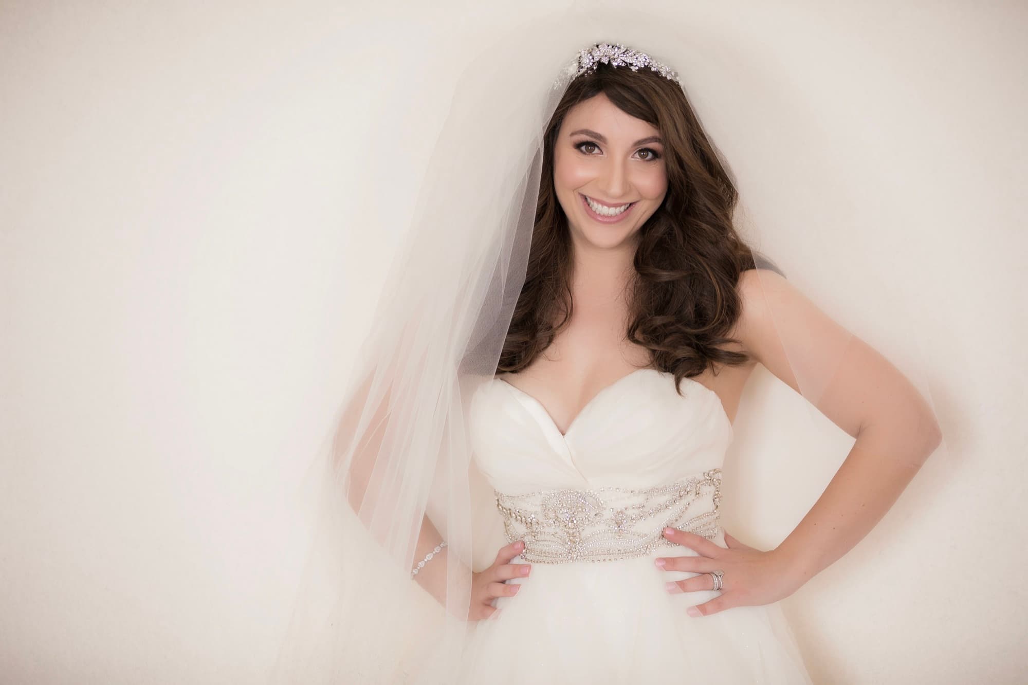 Bridal portrait of Michelle in a tiara and cathedral veil with a jeweled belt on her sweetheart ball gown