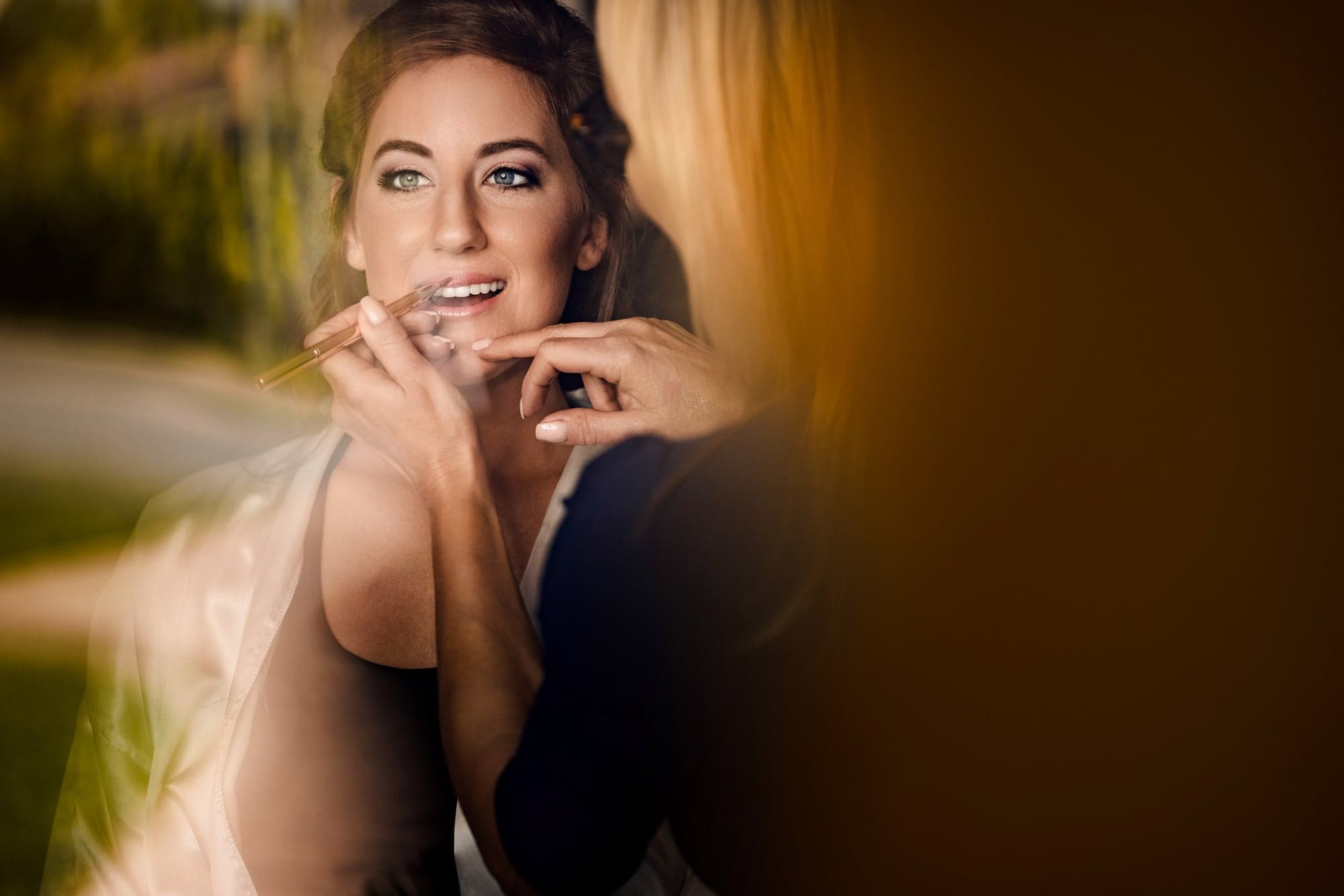 Sarah finishing her wedding preparation in warm window light at Terranea Resort