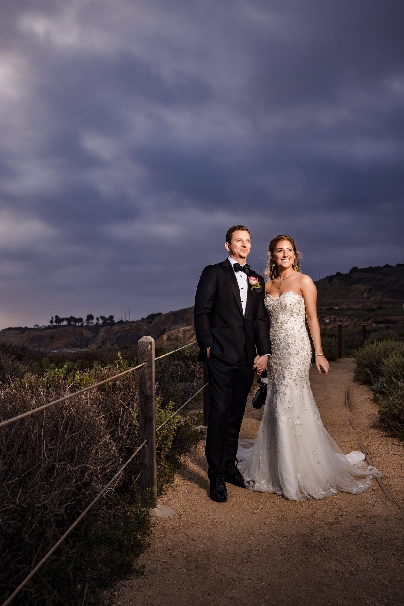 Sarah and Daniel standing together on the Terranea Resort bluffs beneath a dramatic evening sky, photographed by Michael Anthony Photography