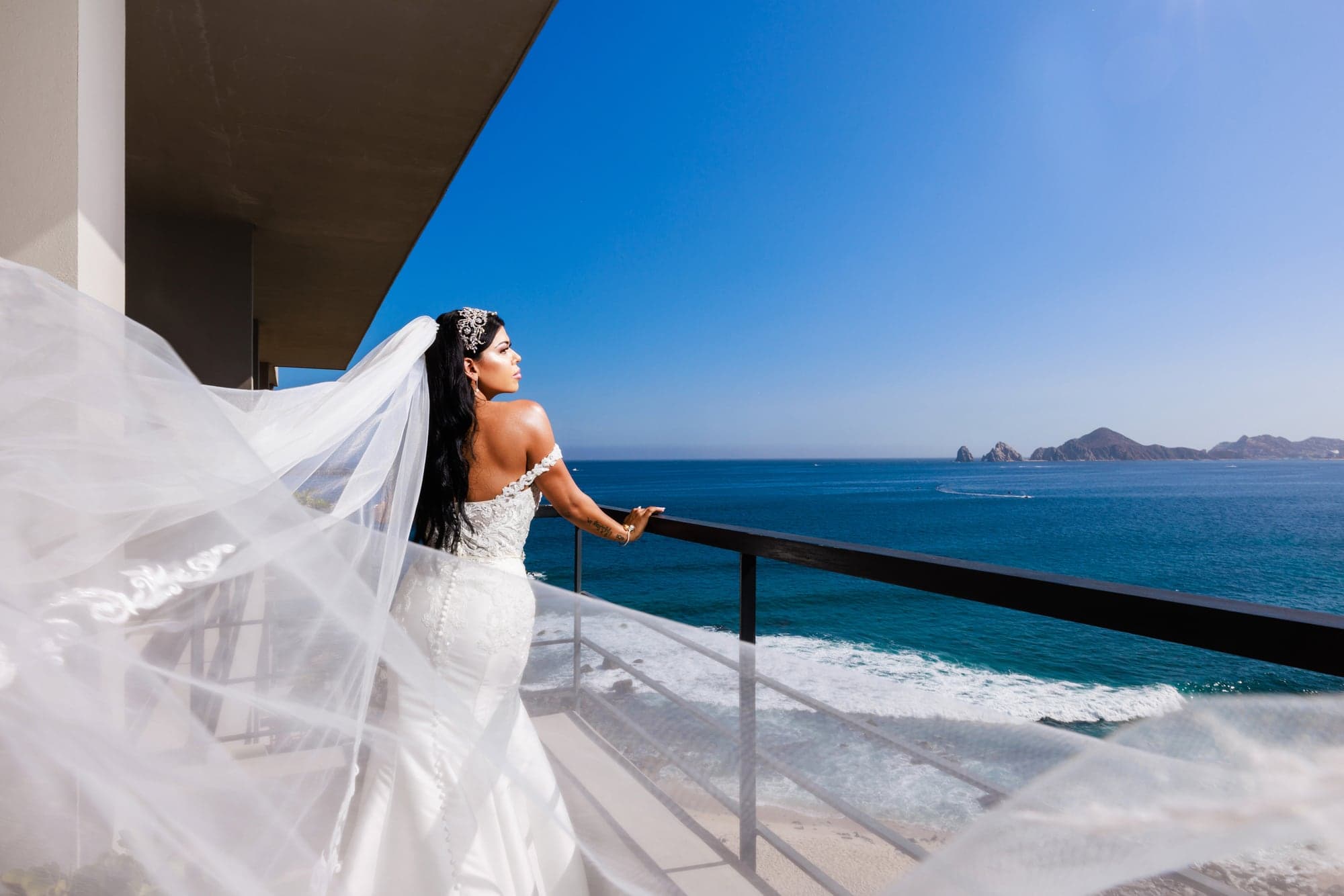 Bryanna standing on a private balcony overlooking the ocean at The Cape Cabo