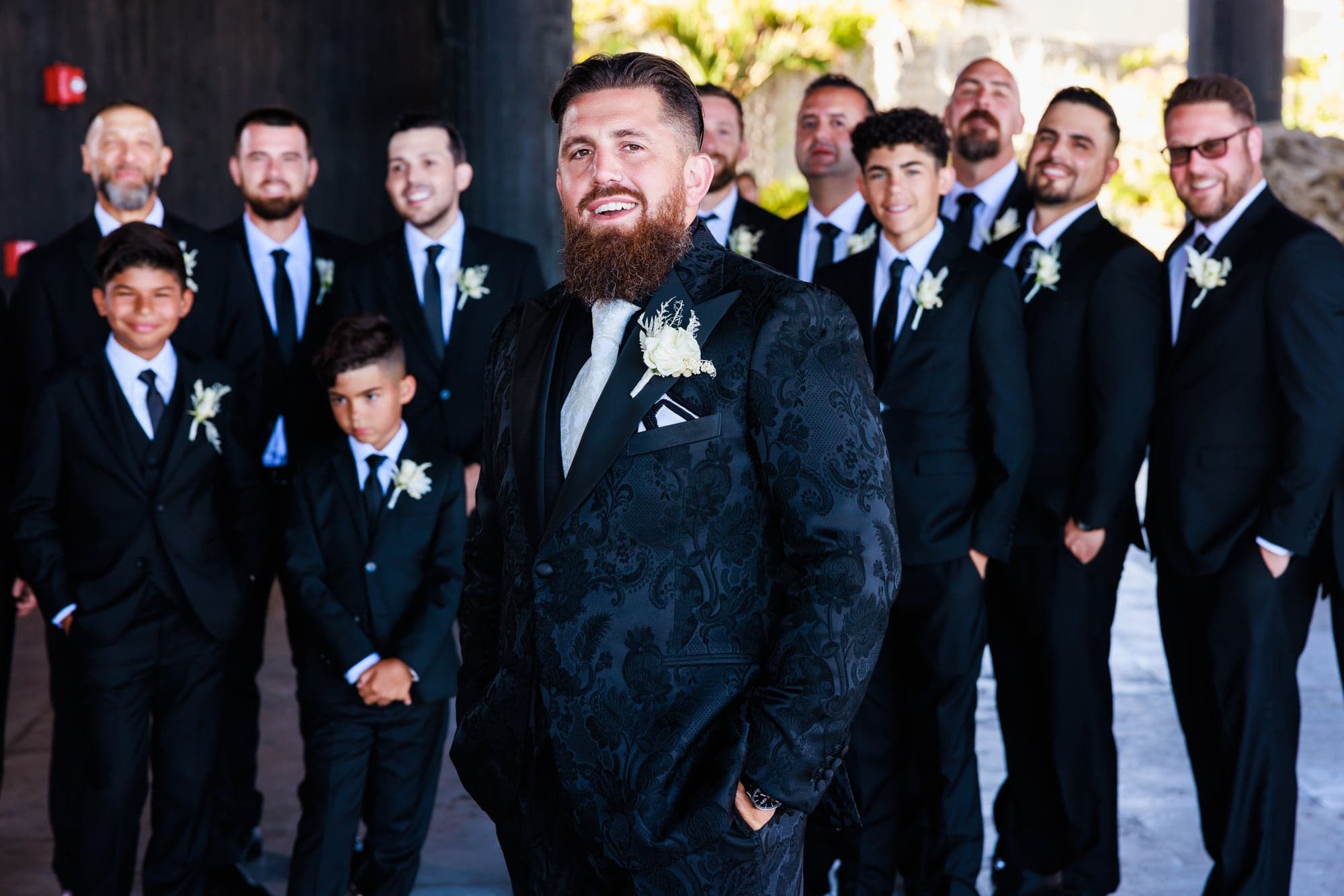 Justin with his wedding party in black tuxedos at The Cape Cabo