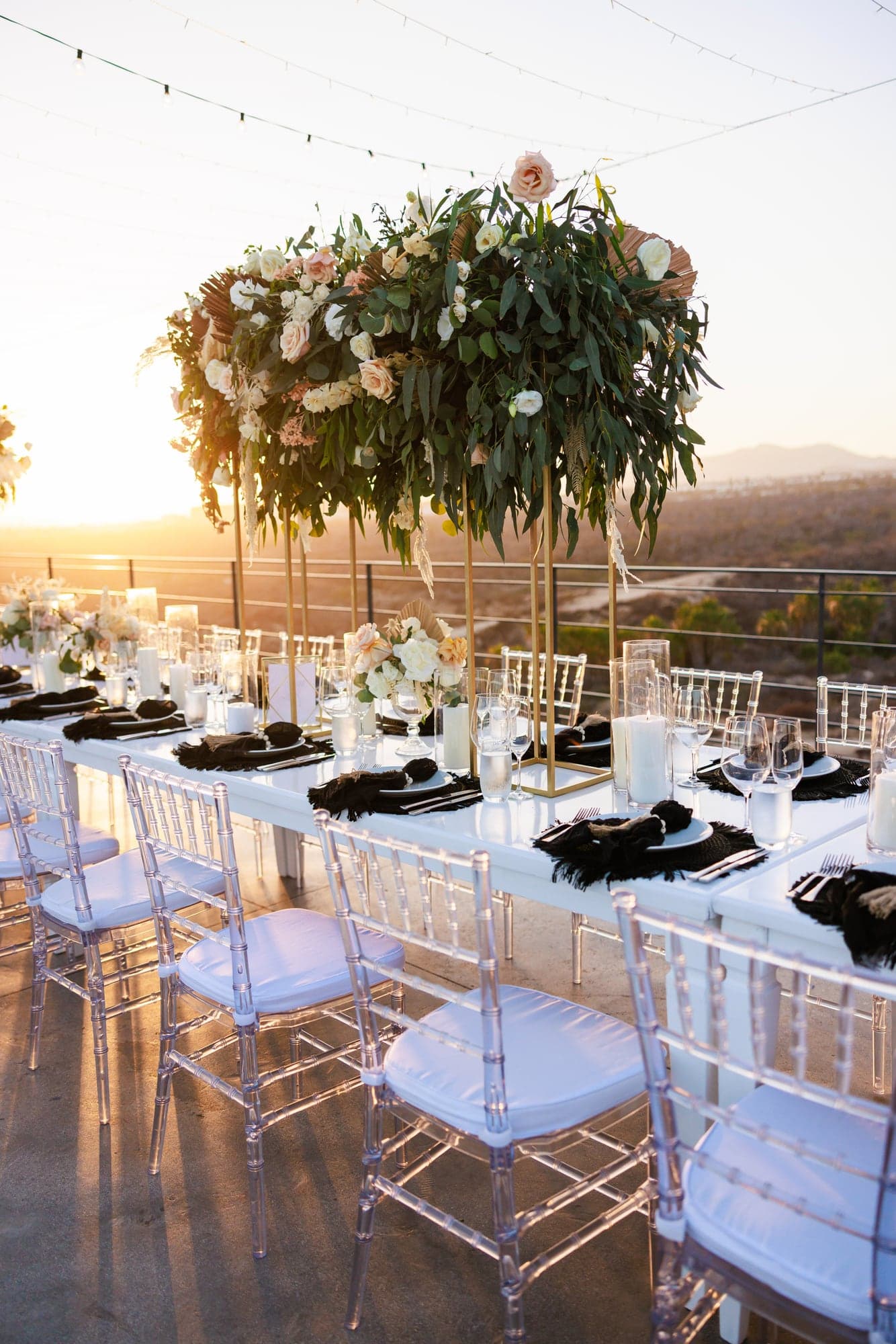 The open-air reception at The Cape Cabo prepared with sculptural florals and black chairs