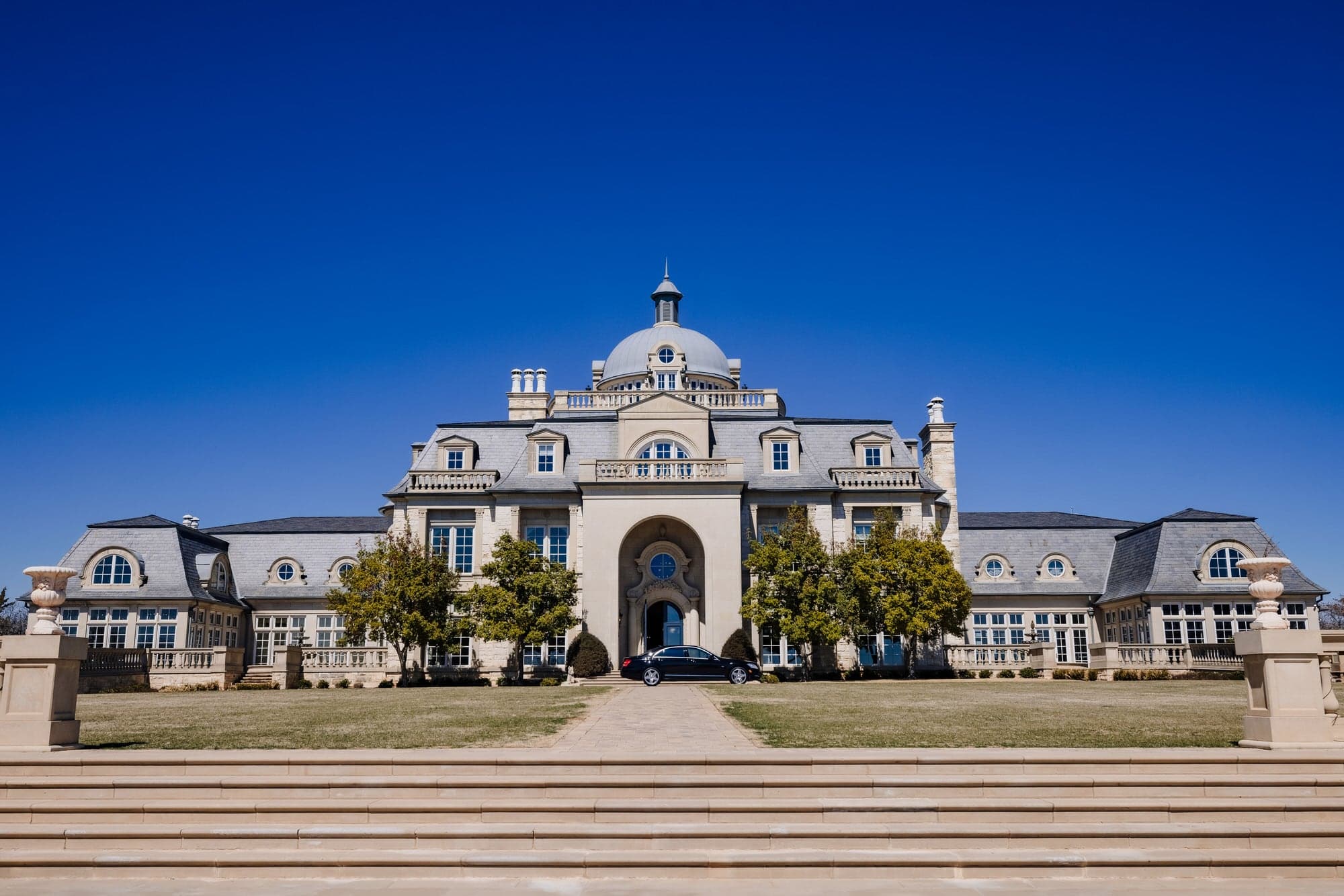 The grand symmetrical facade of The Olana beneath a clear North Texas sky