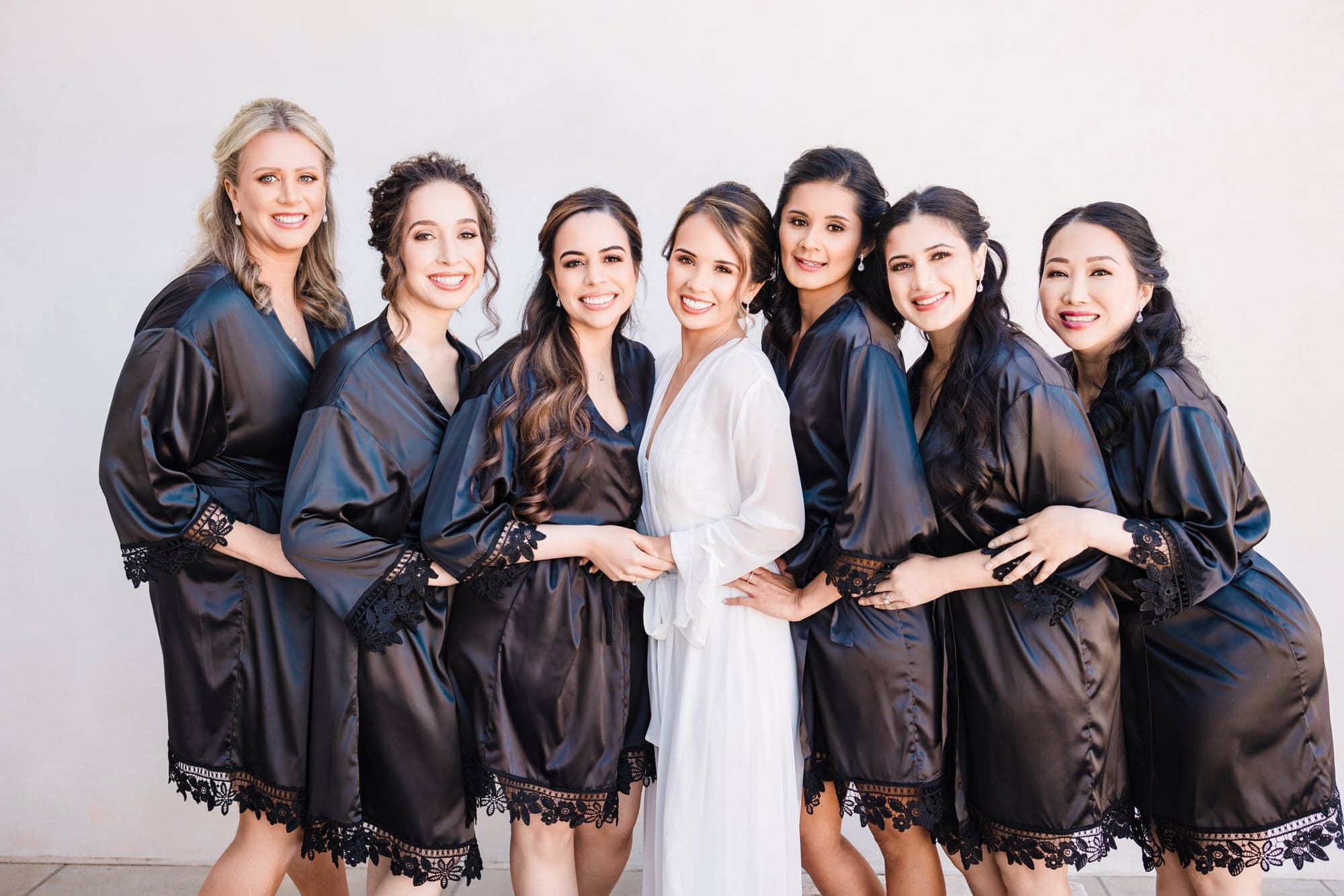 Ana with her wedding party in coordinated black robes inside The Olana