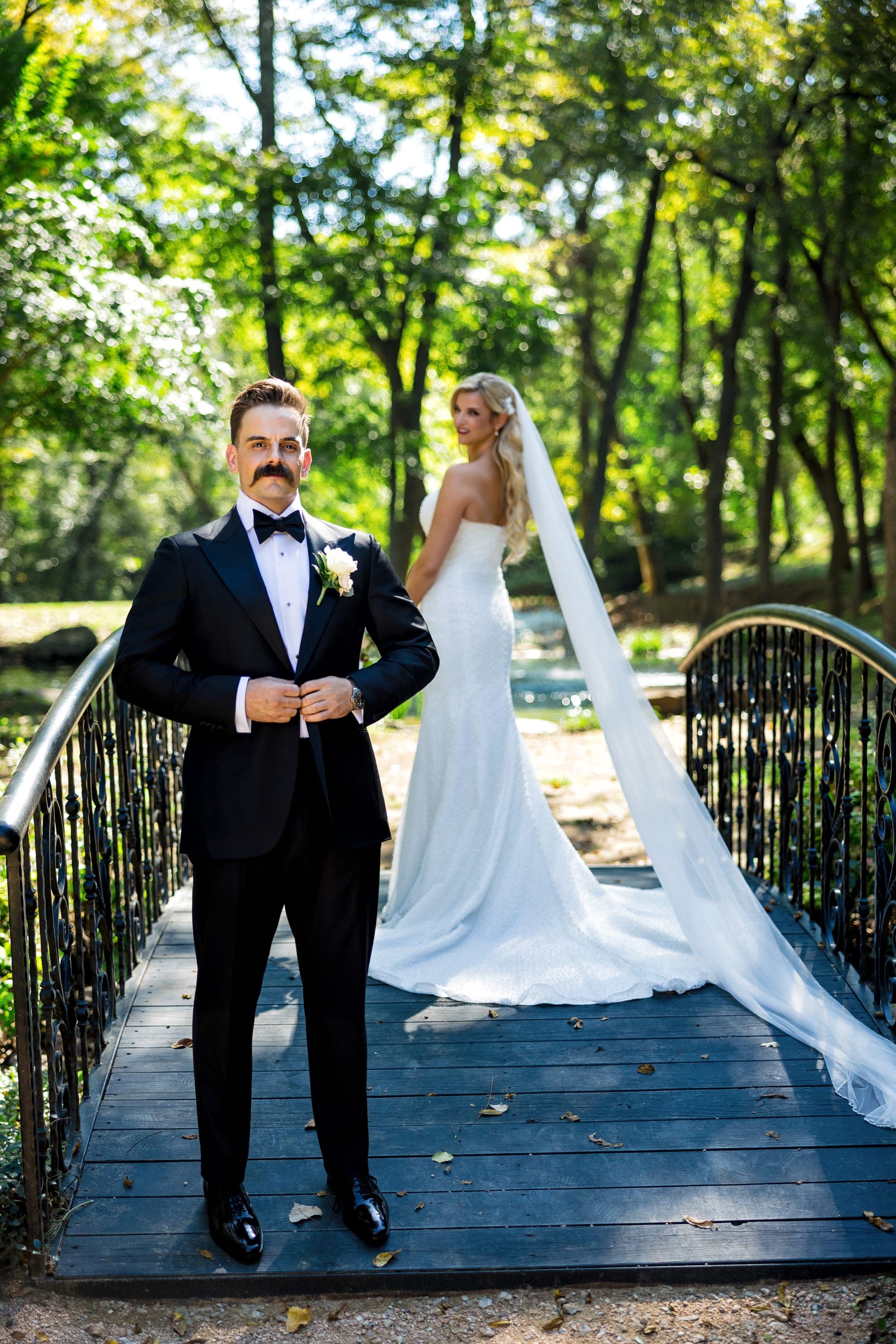 Beth and Austin on the iron footbridge with her veil sweeping behind her