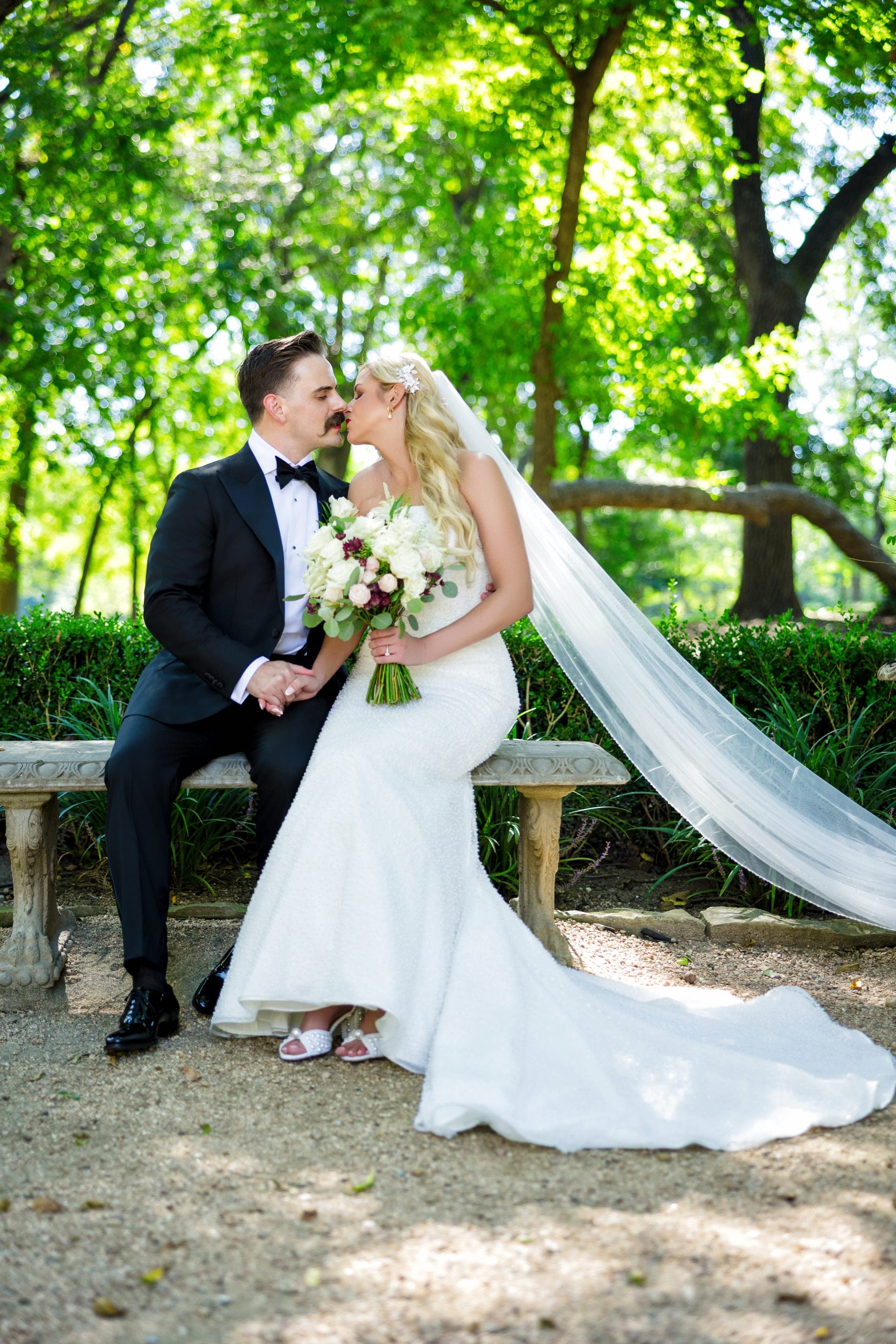 The couple close together on the bridge beneath the trees