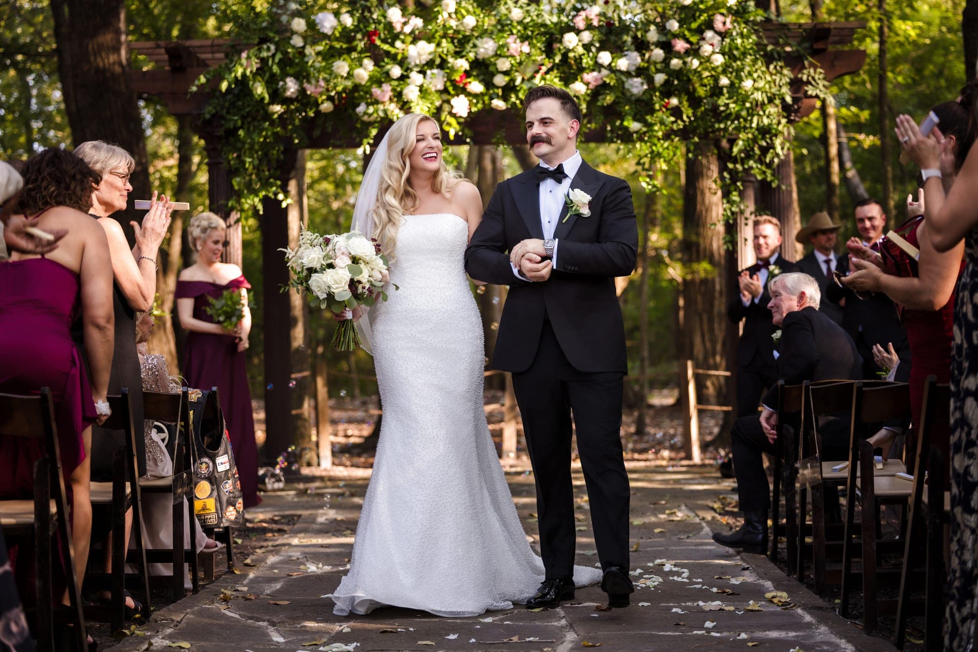 Black and white photograph of Austin dipping Beth in the aisle after the ceremony