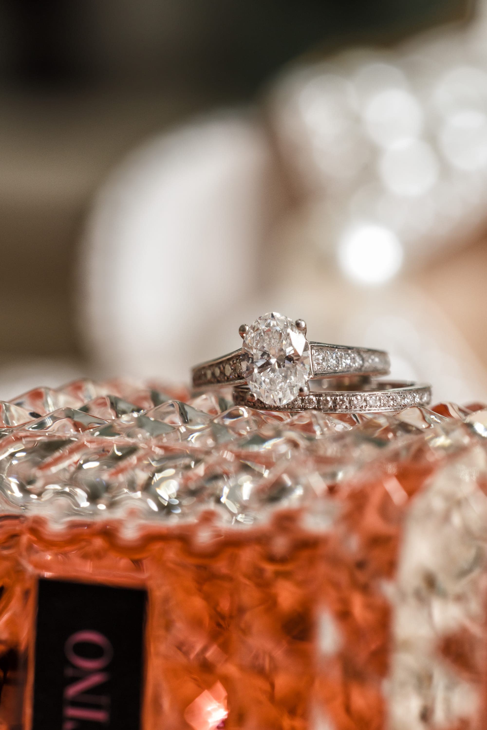 Beth's engagement ring and wedding band photographed on beaded fabric