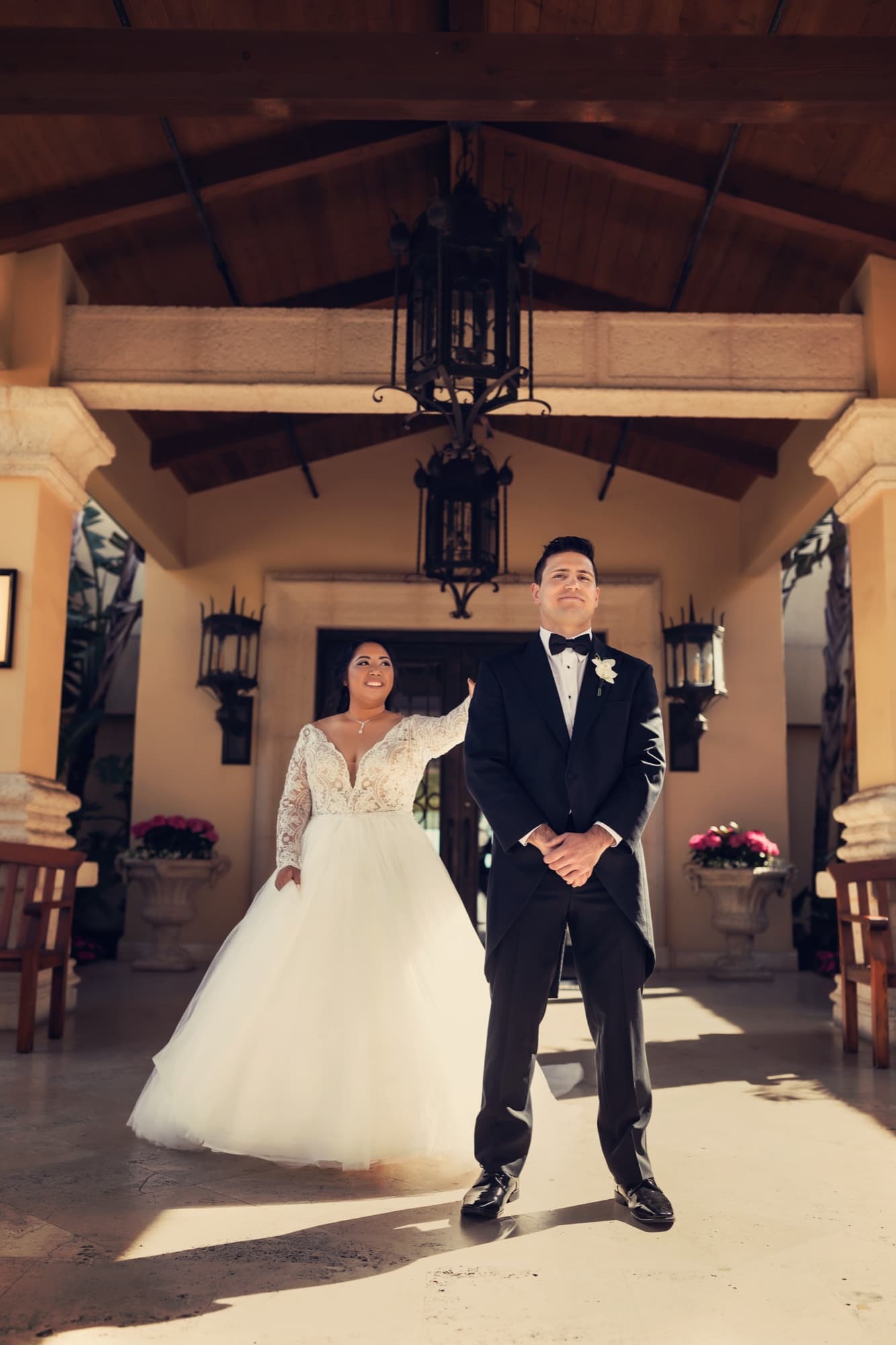 Jamie and James standing together beneath the Spanish-style courtyard arches at Trump National Golf Club