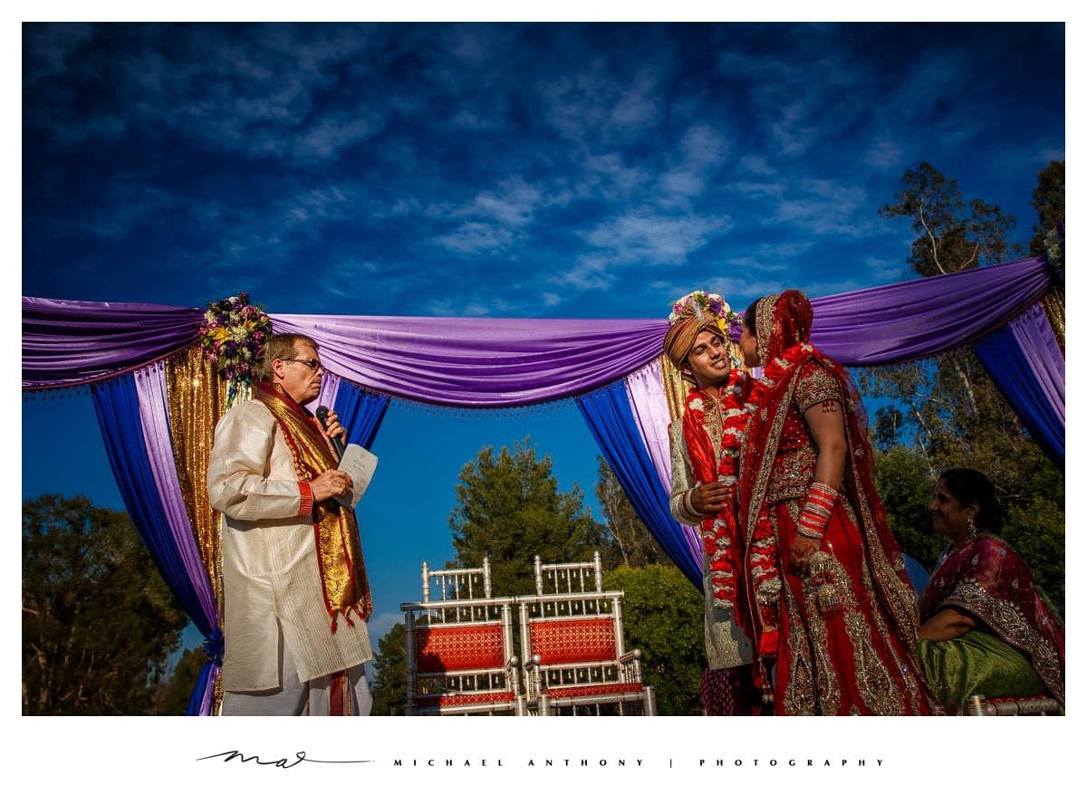 Aneet and Rishi beneath their colorful outdoor mandap