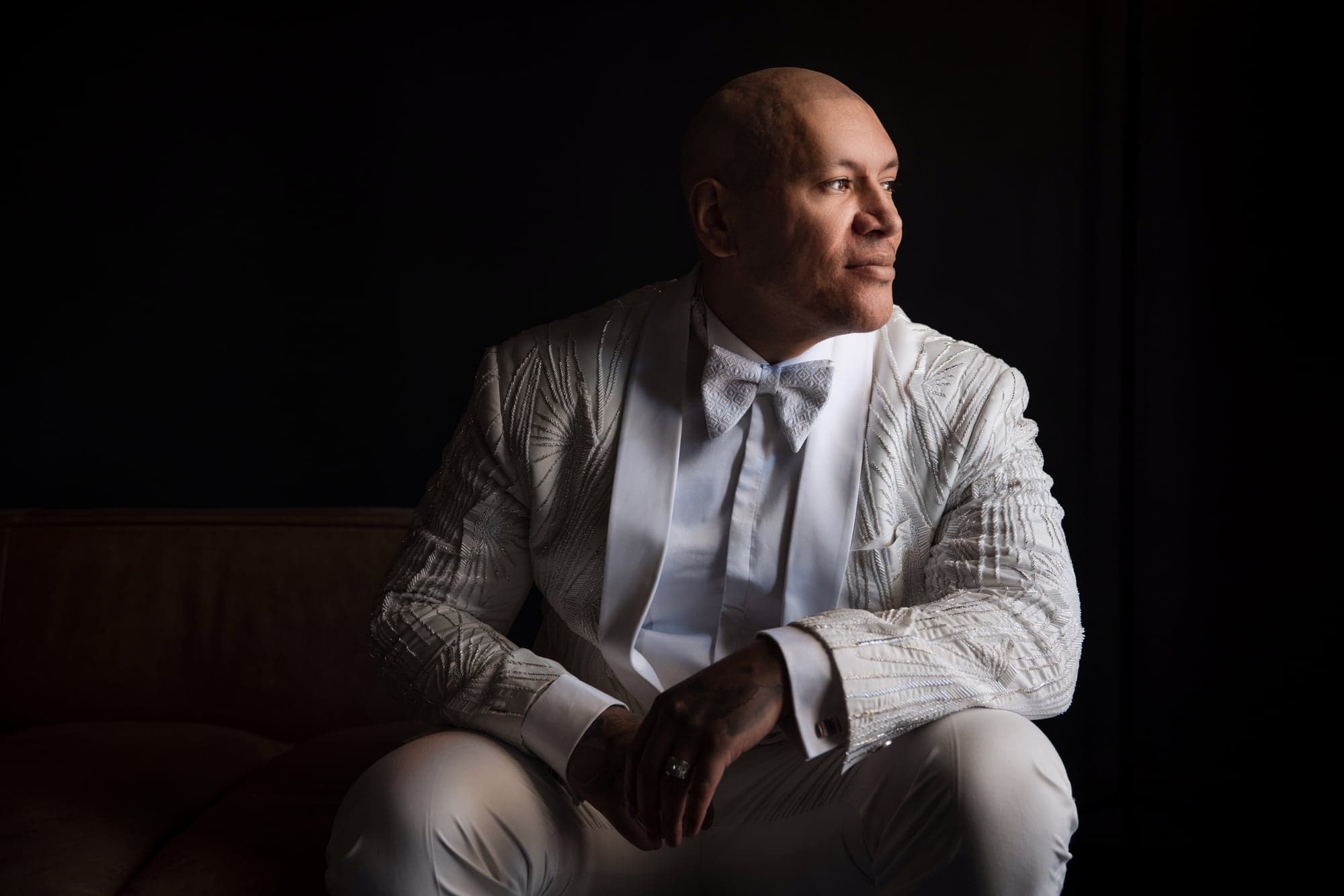 Anthony preparing in a white dinner jacket before his Vibiana wedding