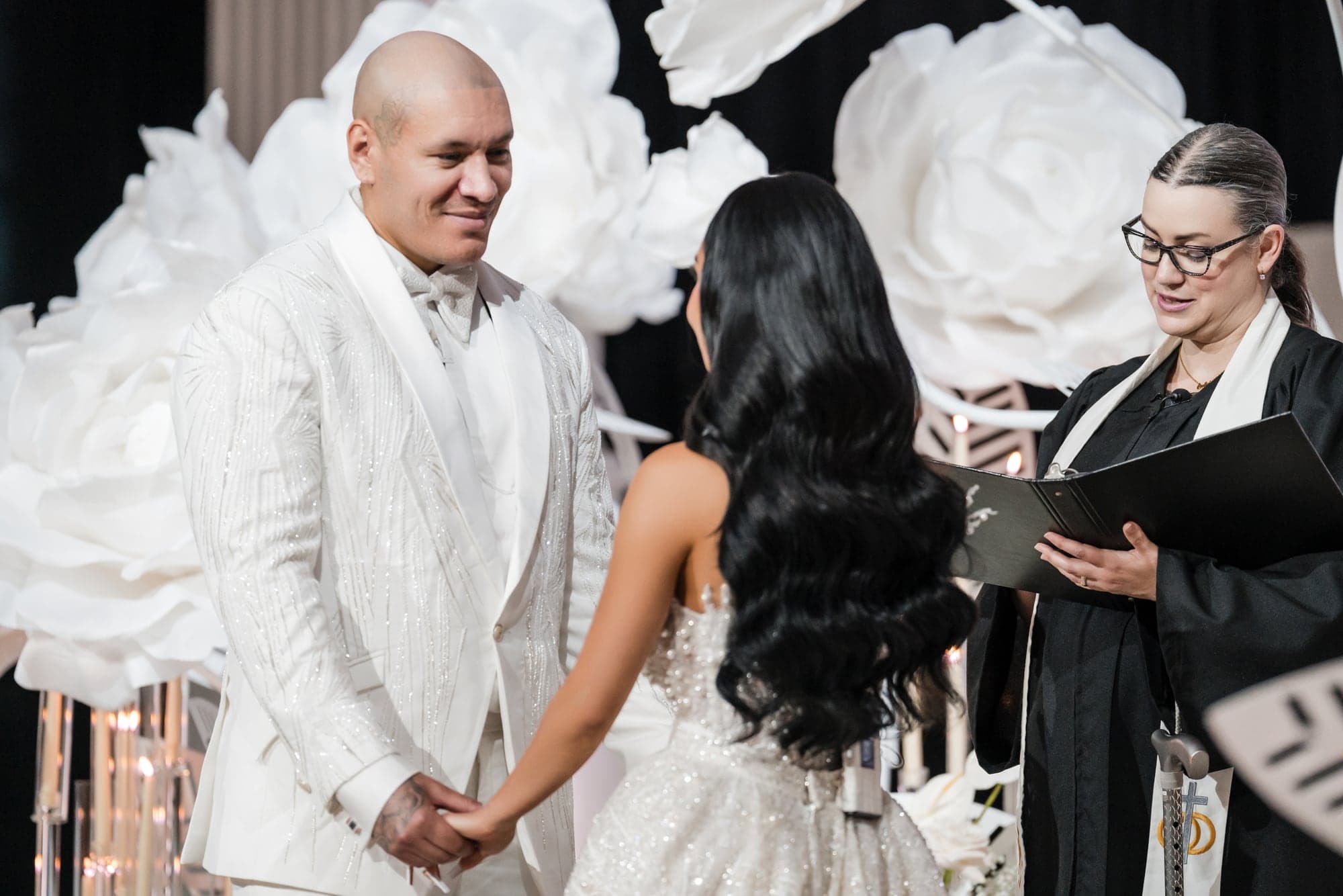 Afrika and Anthony exchanging vows in Vibiana's all-white ceremony design