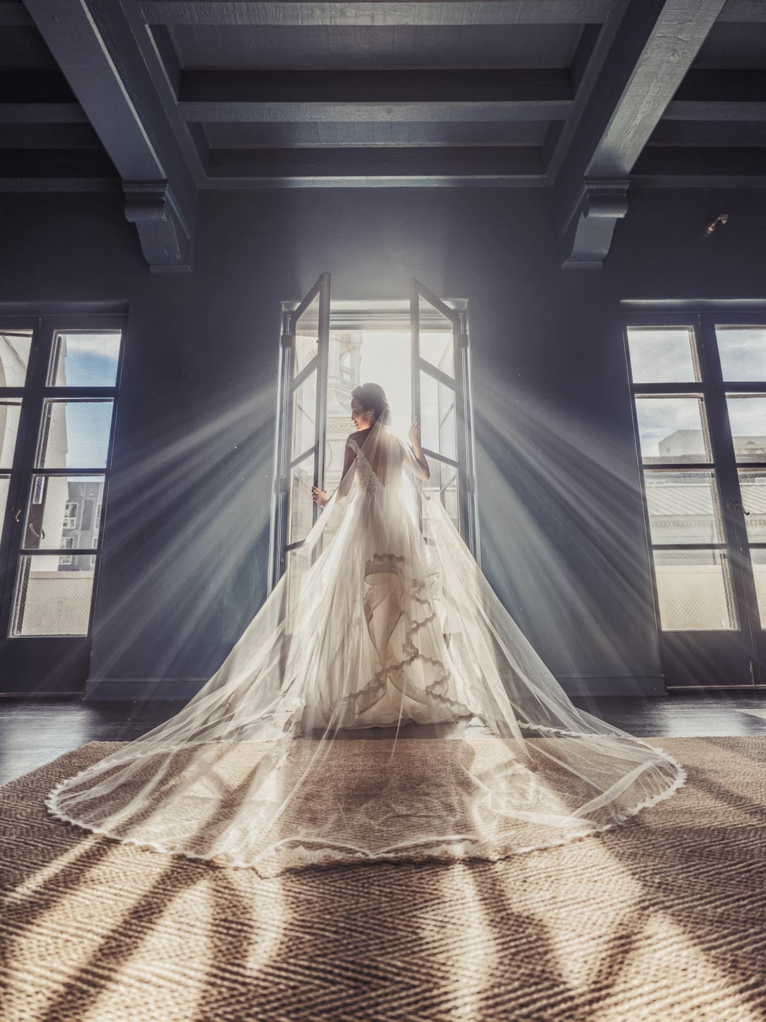 Bride standing in the doorway of Vibiana's bridal suite with light rays streaming through her cathedral veil, photographed by Michael Anthony Photography