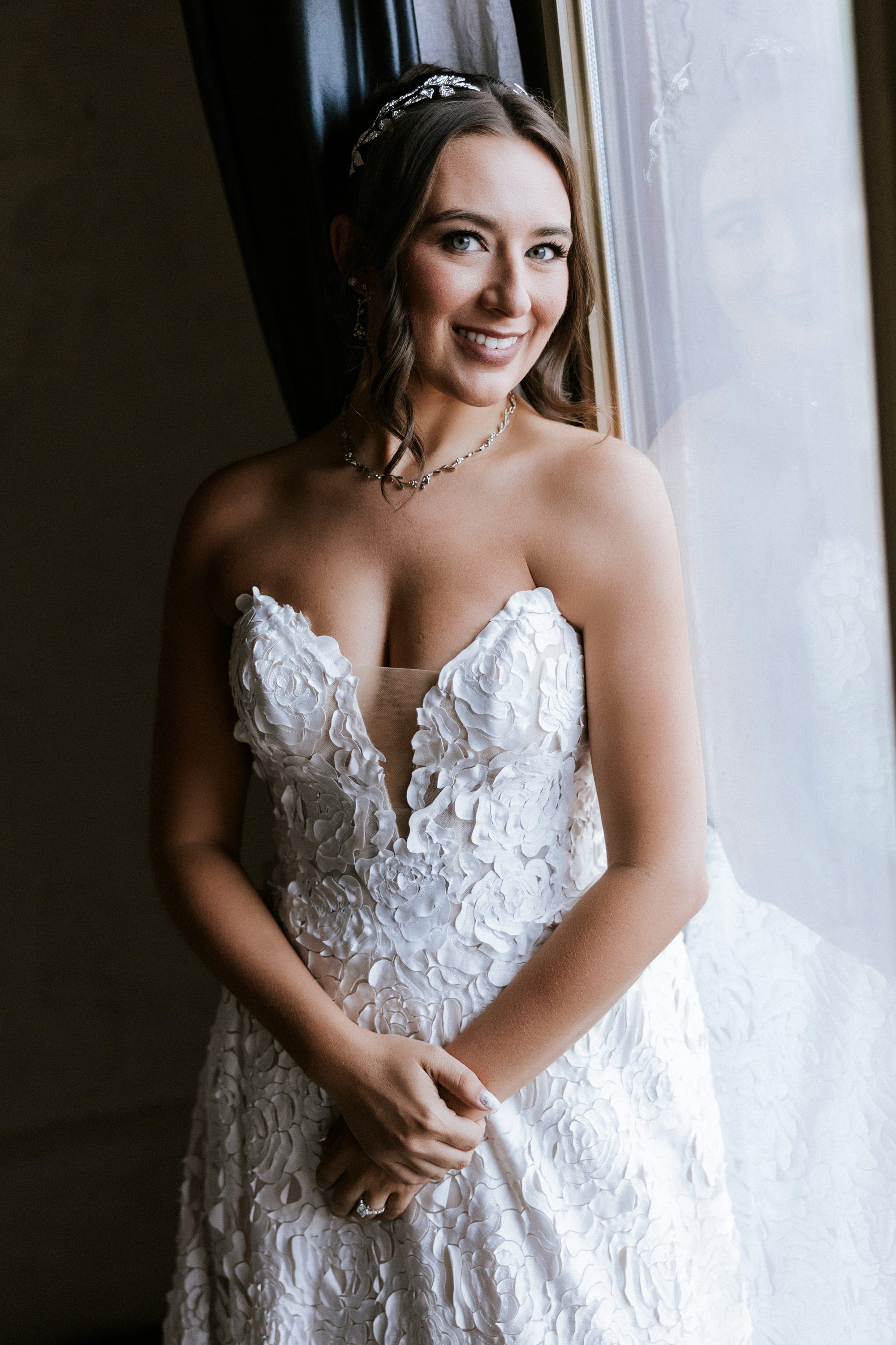 Kelsey in her strapless lace ballgown by the villa window, jeweled headband in her hair