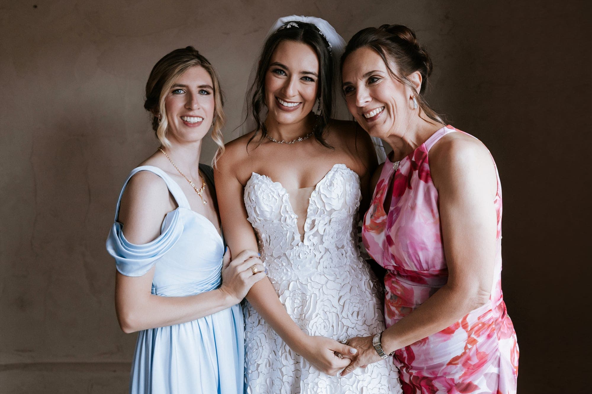 Kelsey with her bridesmaid in light blue and her mother in pink florals