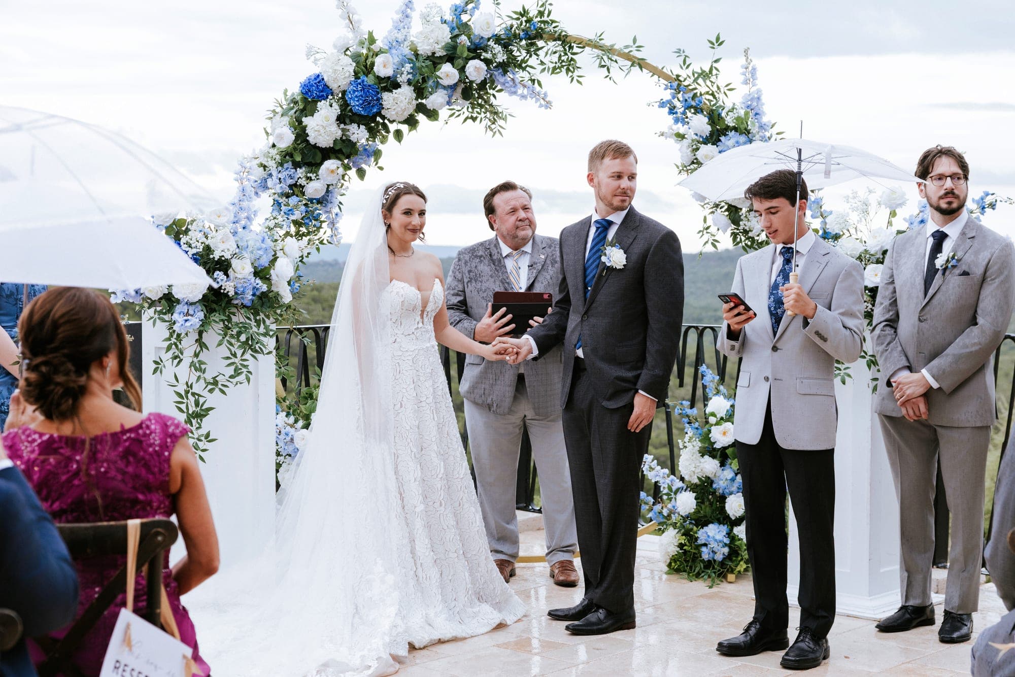 Guests beneath clear umbrellas during the rainy ceremony at Villa Antonia