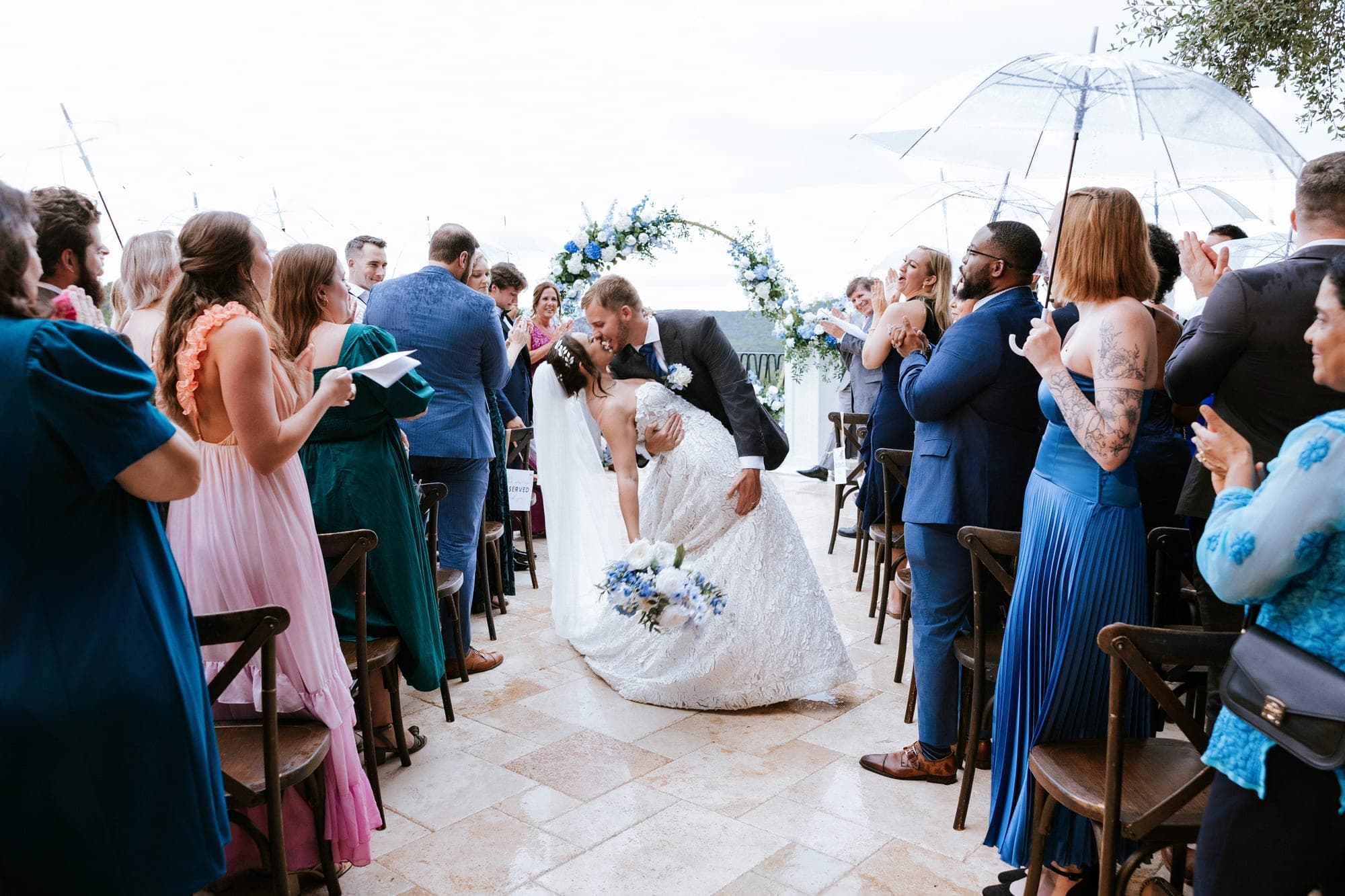 The recessional dip kiss from behind the rows of umbrellas