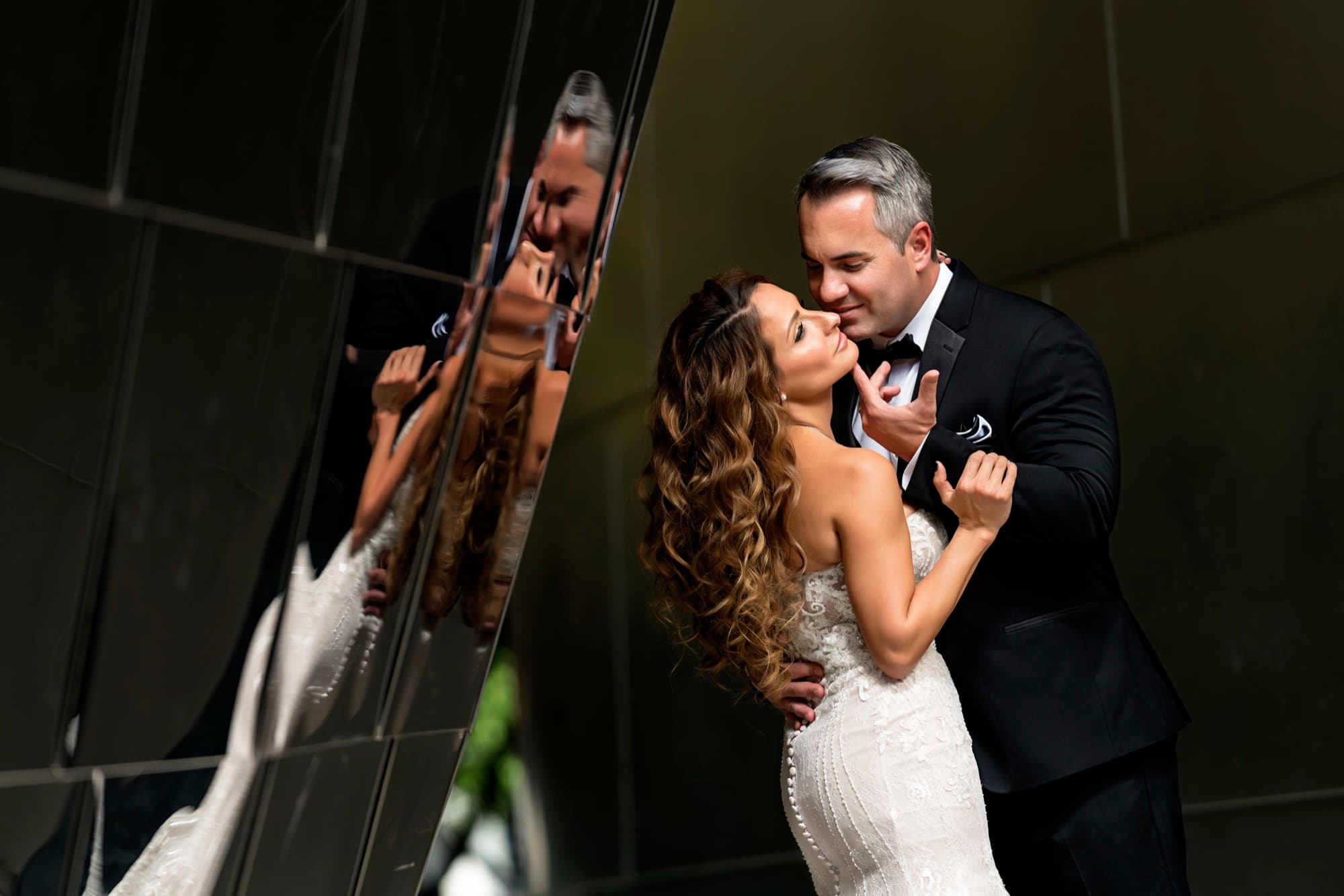 Suzie and Paul reflected in a polished steel panel at Walt Disney Concert Hall as they embrace
