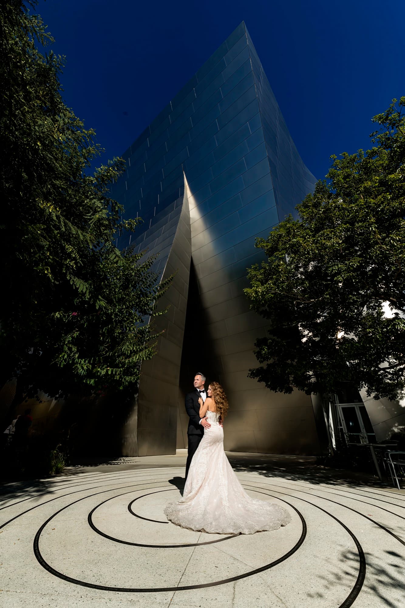 Suzie and Paul at blue hour beneath the uplit steel peak of Walt Disney Concert Hall, framed by trees