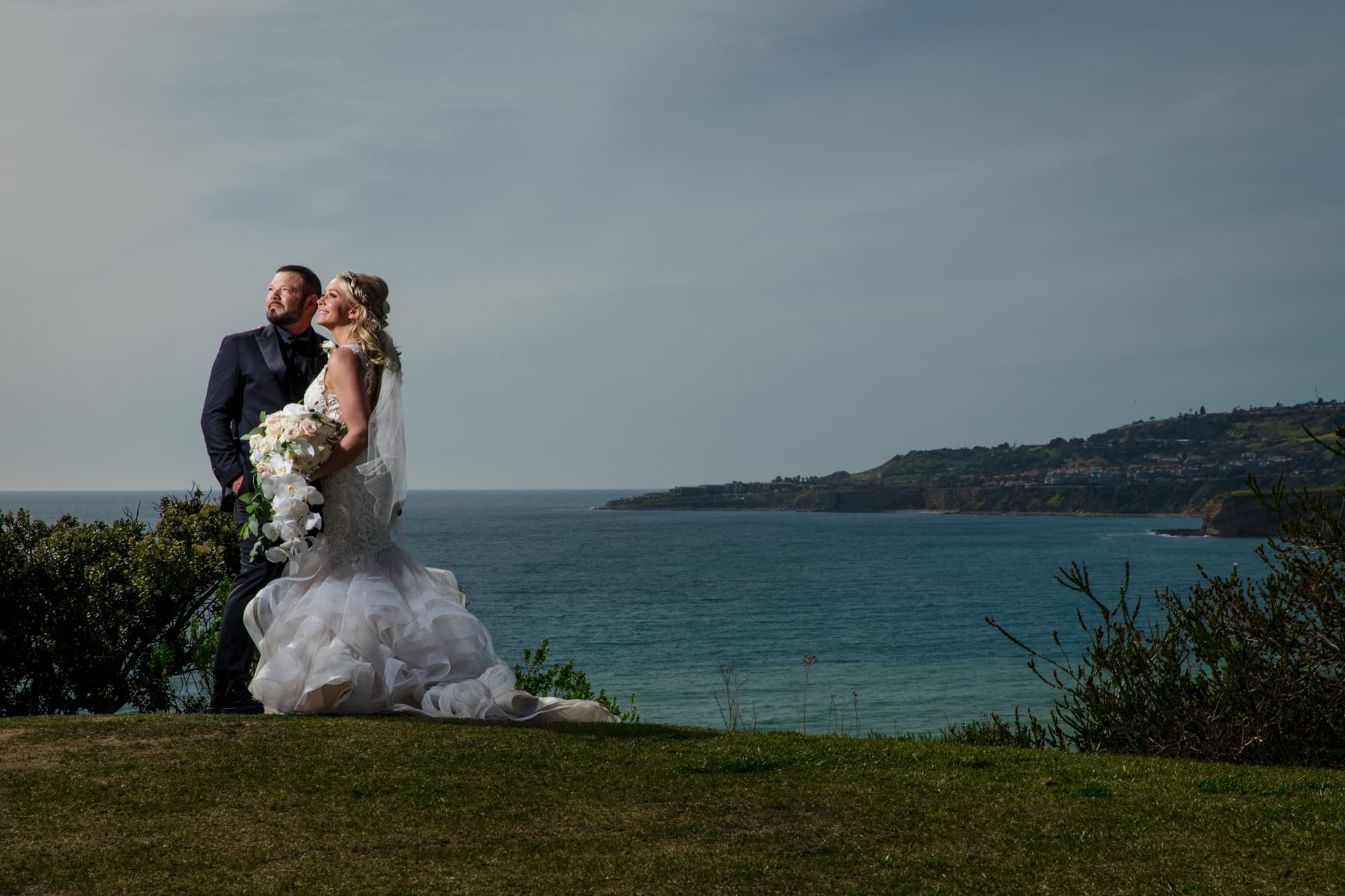 Amanda and Sean on the clifftop at Trump National Los Angeles with the Palos Verdes coastline curving behind them