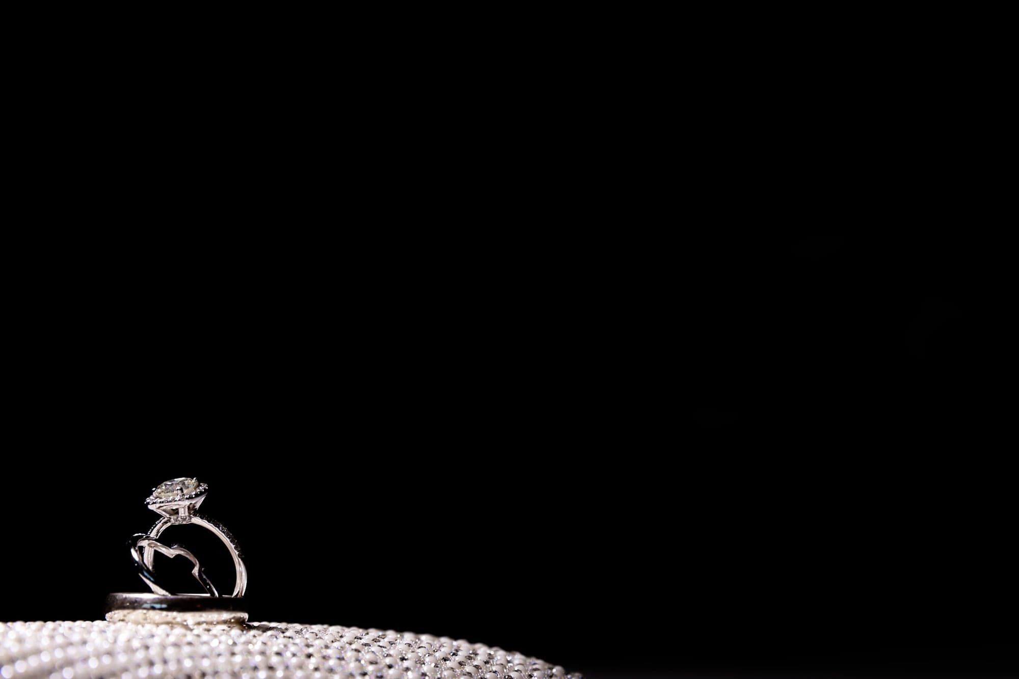 Wedding rings and jewelry photographed against a dark background