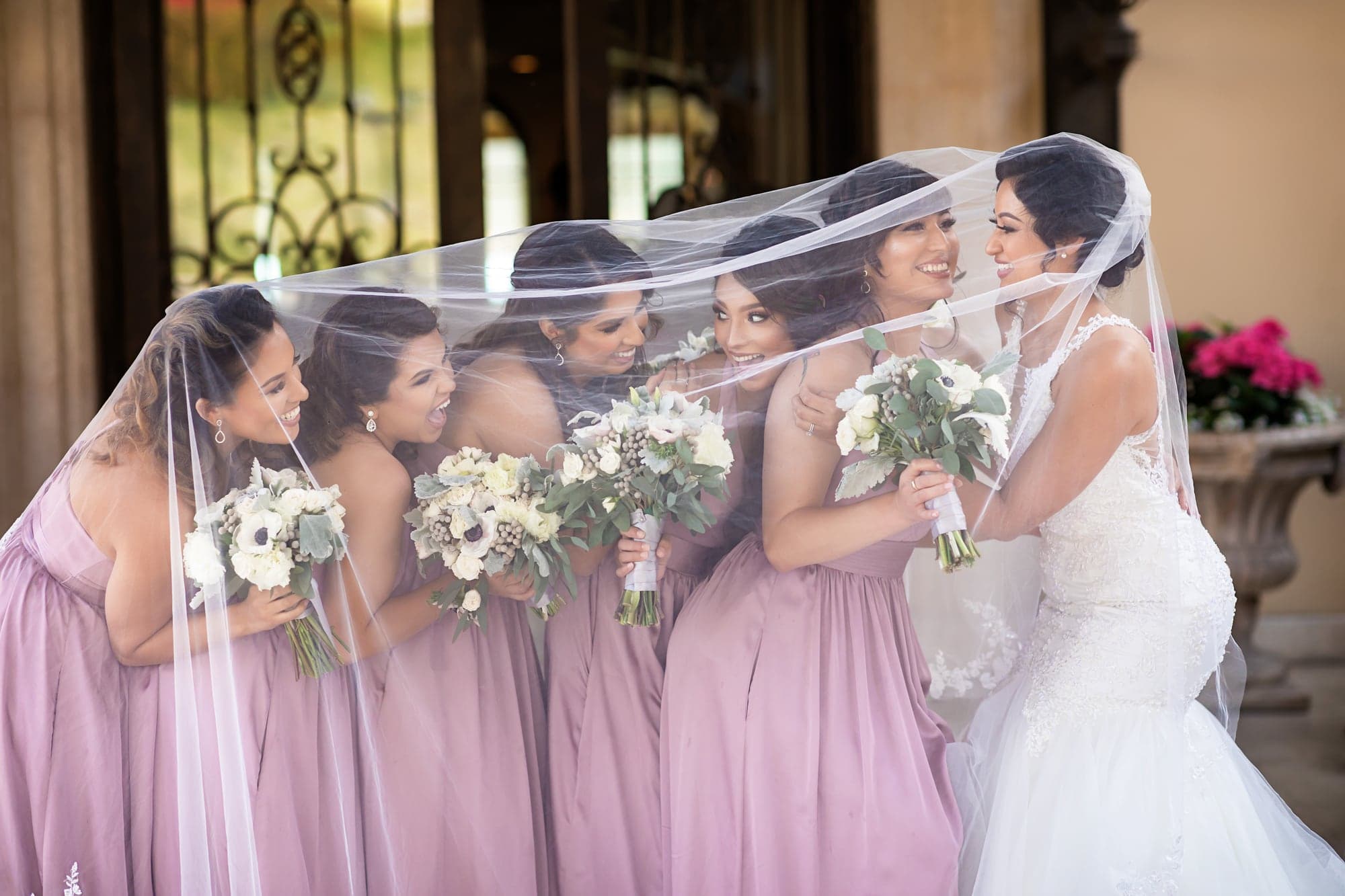 Bride with her attendants beneath a sweeping veil
